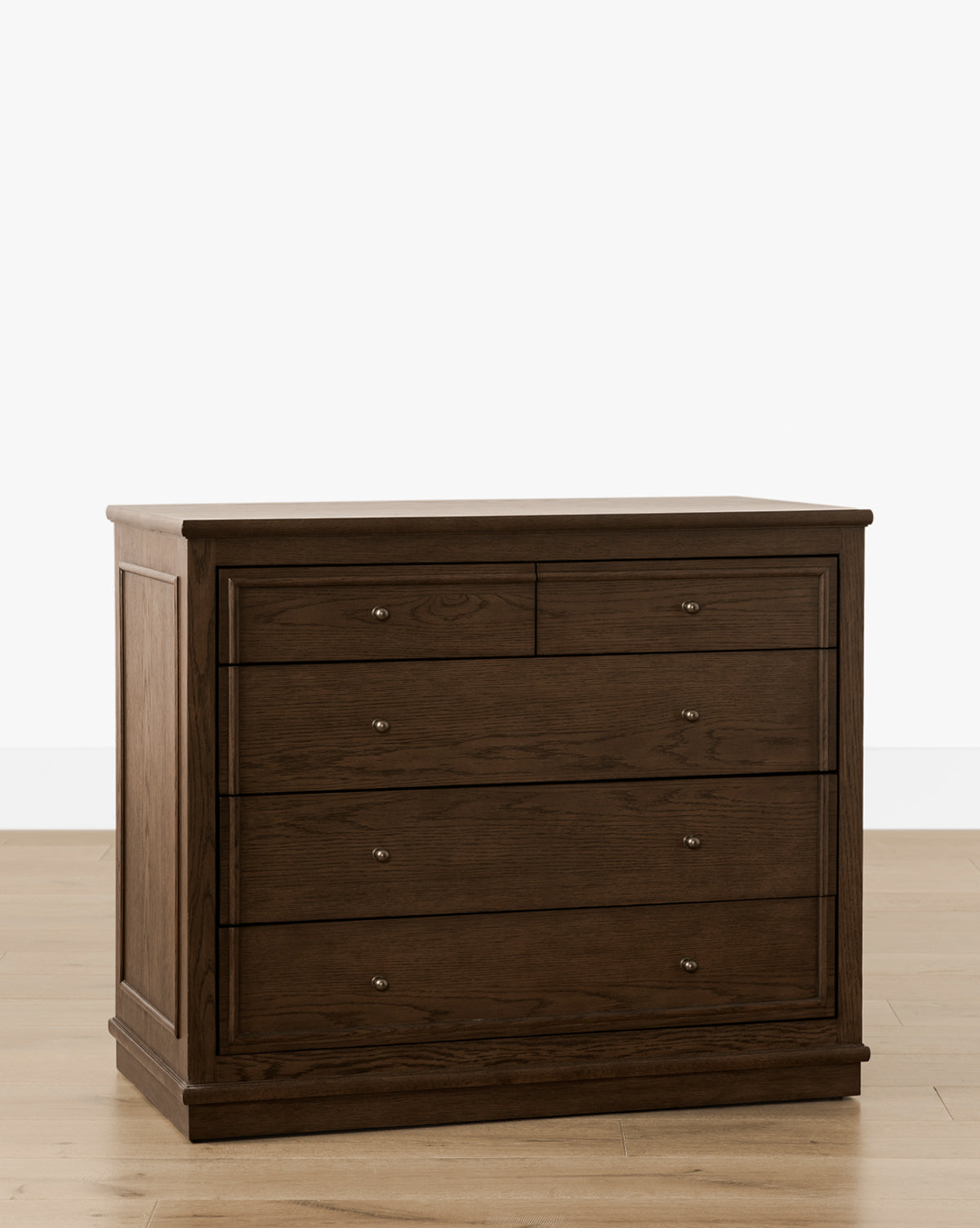 The Yorkshire Dresser in dark brown English oak features two small top drawers and three larger lower drawers with round metal knobs, providing elegant bedroom storage on a light wood floor against a white background, by McGee & Co.