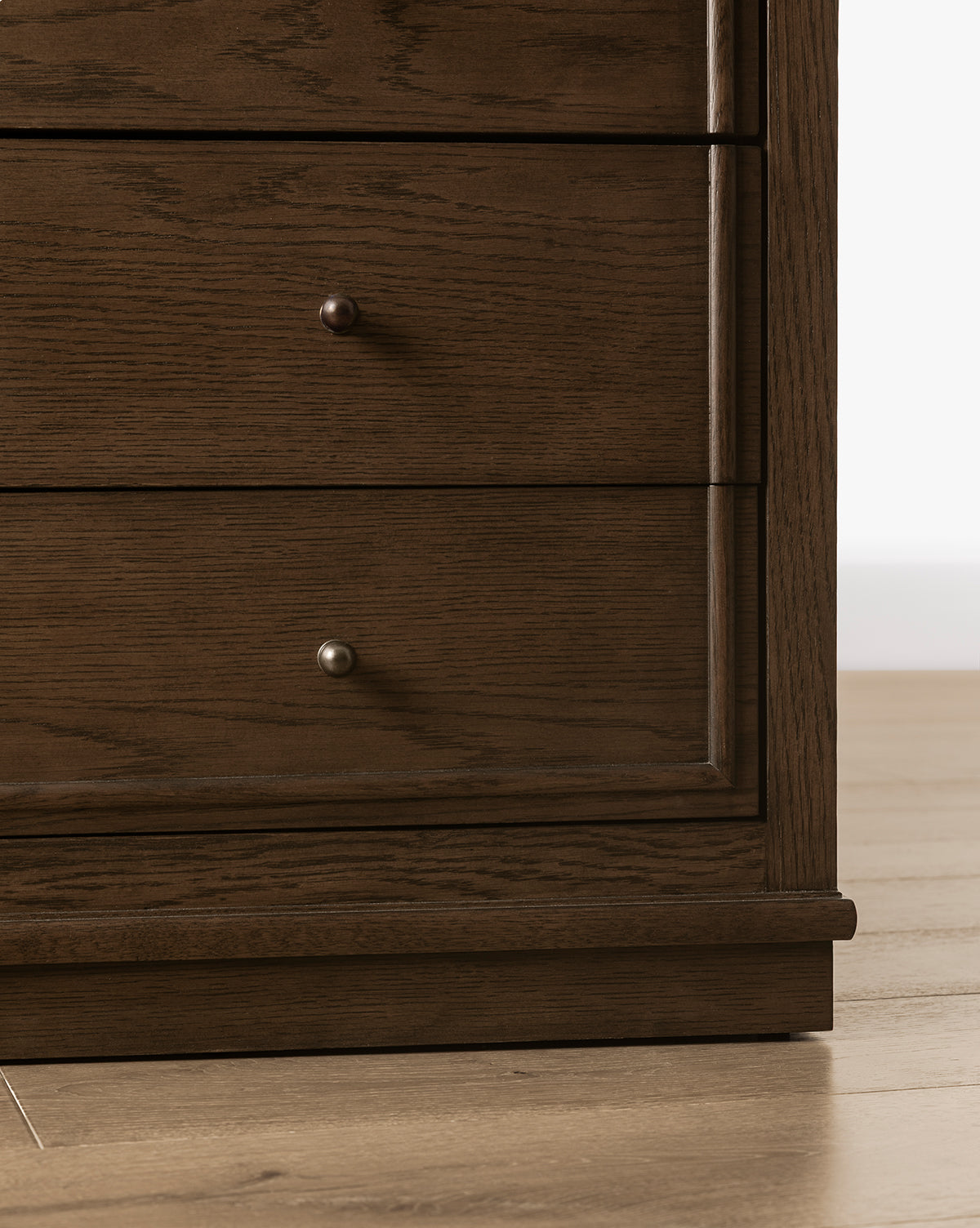 Close-up of the lower section of the Yorkshire Dresser, a bedroom storage piece with two drawers featuring small round metal knobs, standing on a wooden floor, by McGee & Co.