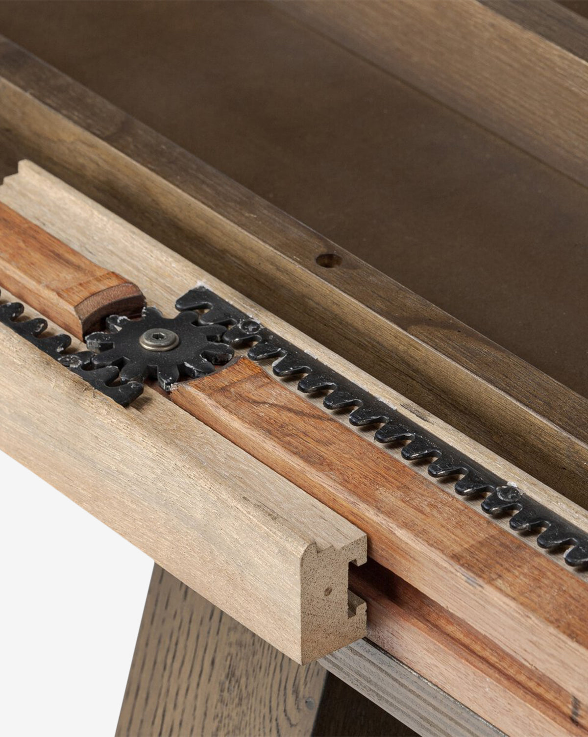 Close-up of the Yvonne Dining Tables wooden mechanism, highlighting a metal gear and toothed track, detailed craftsmanship, oak woodgrain, and a rich dark finish as part of its extension feature, by McGee & Co.