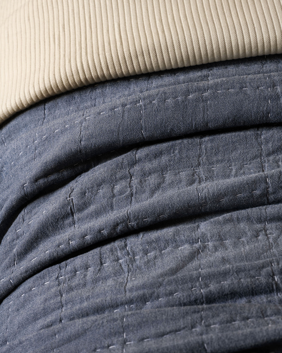 Close-up of a beige ribbed fabric on the Fitzgerald Kids Quilt, featuring blue cotton with white stitched grid pattern. The visible textures and stitching make it perfect for stylish twin kids bedding.