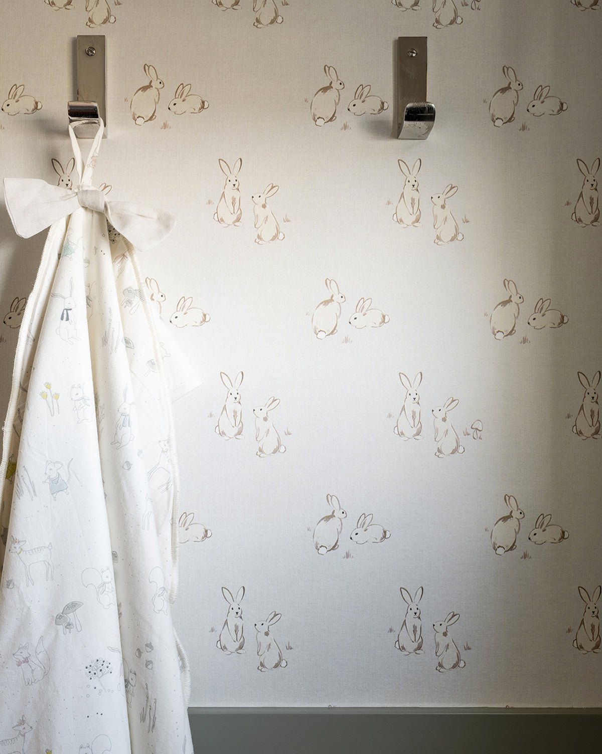 Wallpaper featuring darling bunnies in couplets with a soft gray and taupe palette for a sweet look by McGee & Co.