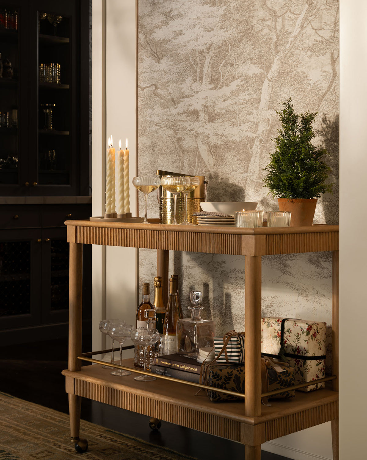 It stands before tree-patterned wallpaper for a cozy and elegant touch, by McGee & Co.