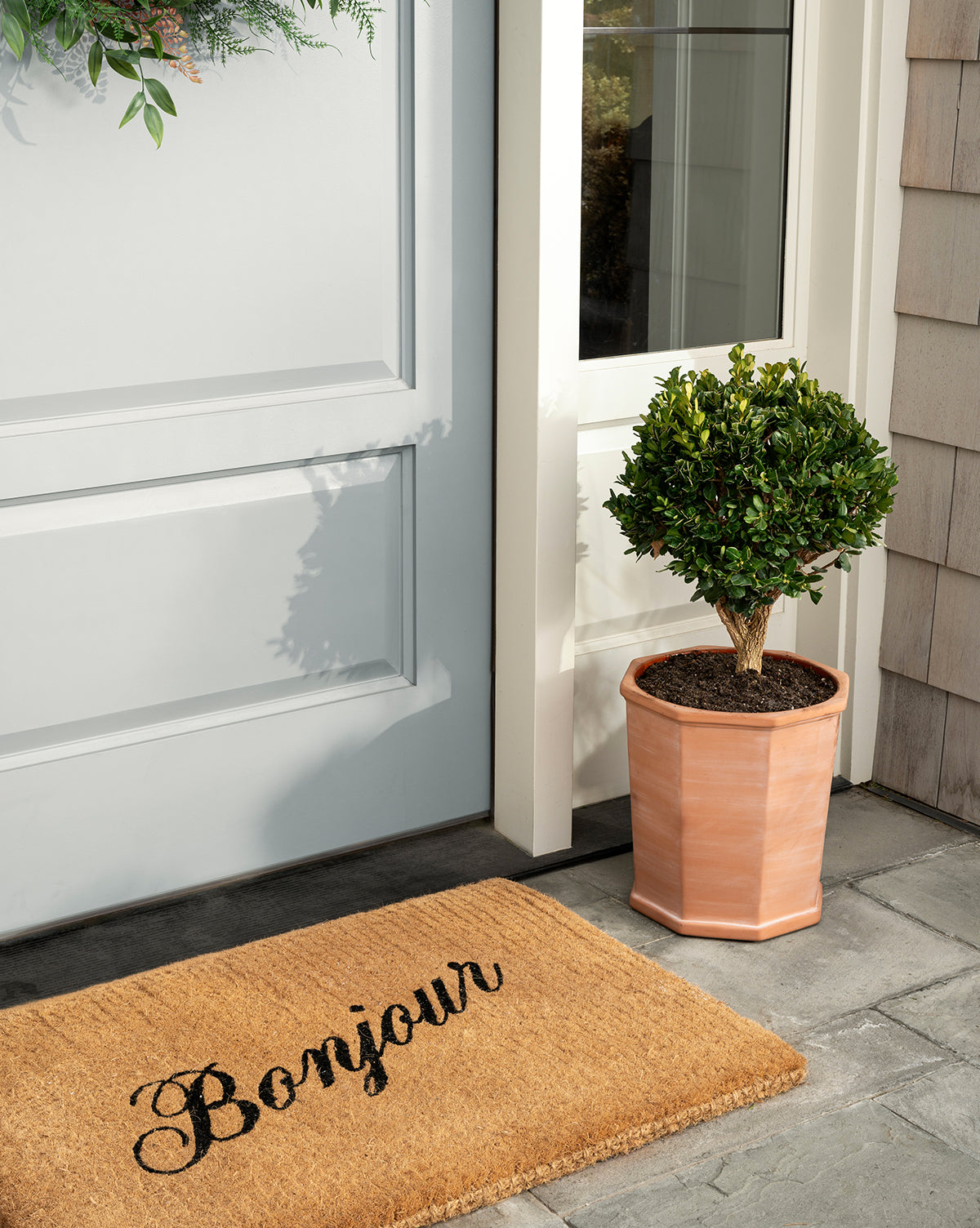 Dempsey Planter in terracotta, shown in small and large sizes on a front porch, from McGee & Co.