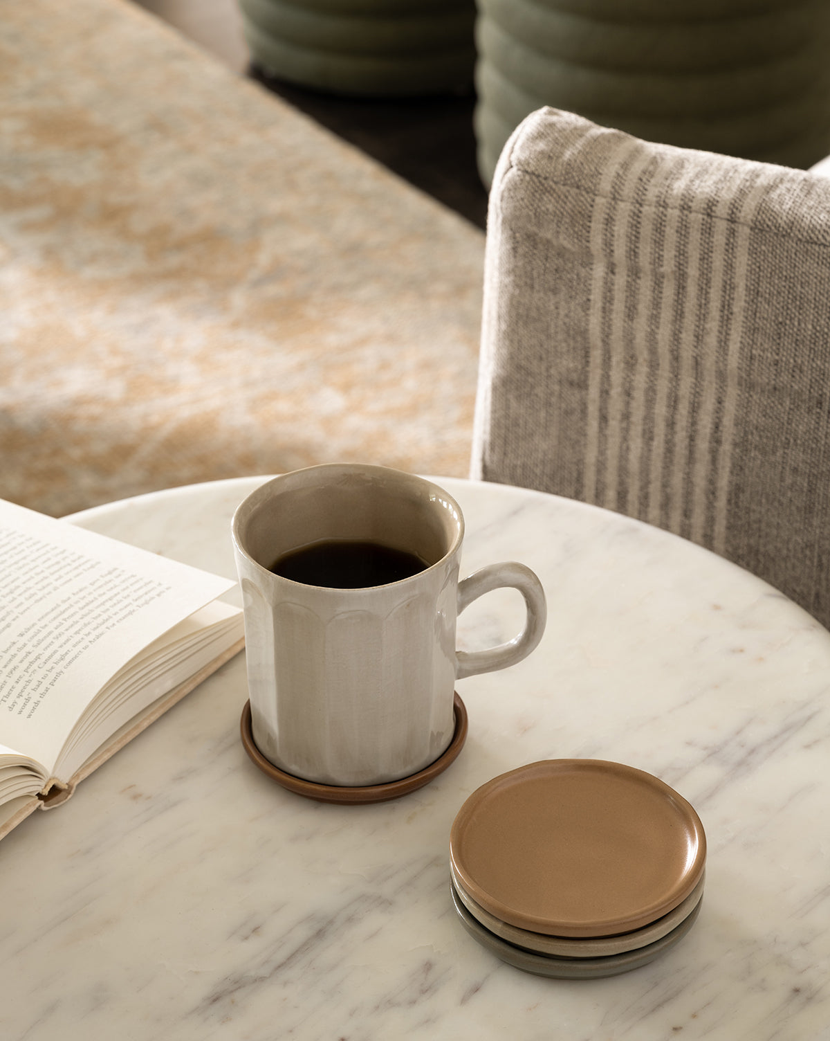 A striped upholstered chair appears in the background, by McGee & Co.