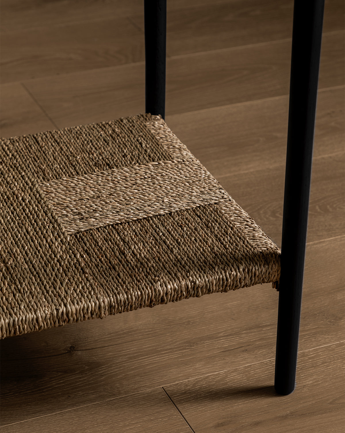The Dana Console features a woven straw shelf with a patchwork pattern and sturdy black metal legs, making it the perfect entryway decor piece to add texture and style to your space, by McGee & Co.