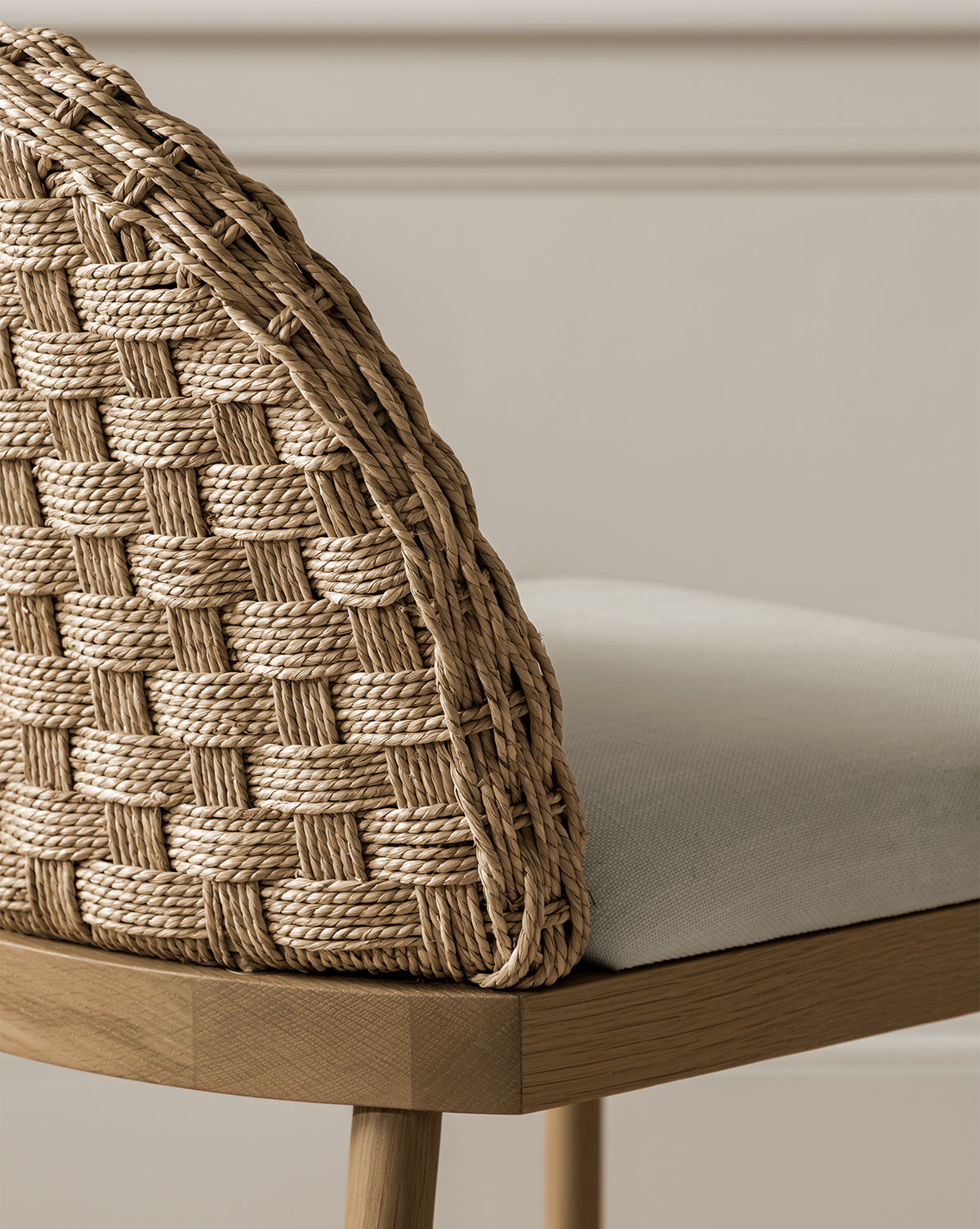 A close-up of the Molly Stool, featuring a solid oak frame, woven rattan backrest, and light beige upholstered seat, placed against a neutral wall with decorative molding, by McGee & Co.