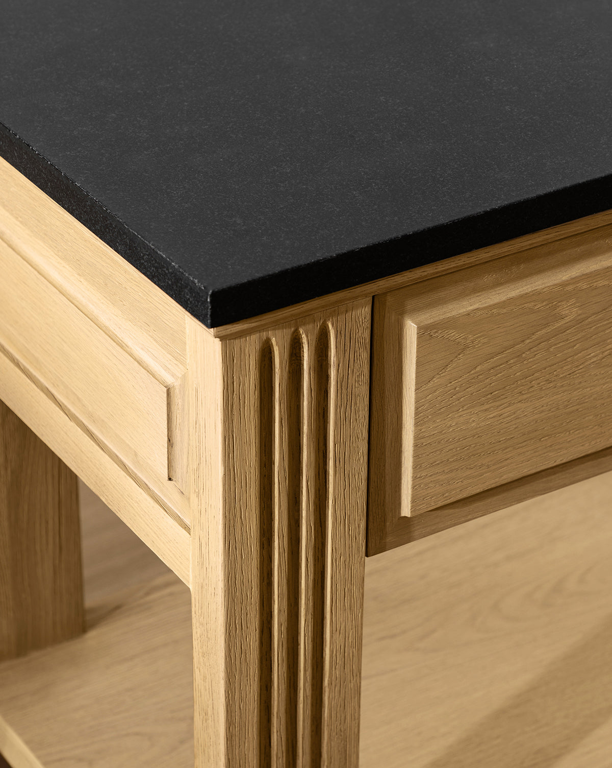 Close-up of the Ambrose Nightstand featuring decorative vertical grooves on the corner and a smooth, honed granite top—ideal for vintage bedroom furniture enthusiasts, by McGee & Co.