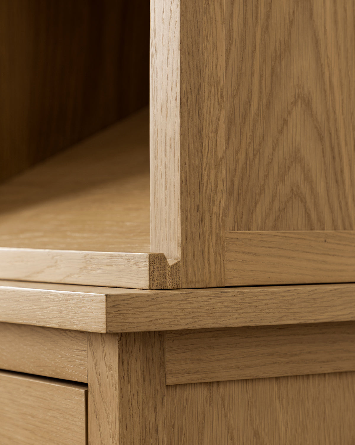 Close-up of the Adler Oak Cabinet’s corner detail, featuring precise joinery, smooth oak grain, clean lines with a natural finish, and clever storage solutions by McGee & Co.