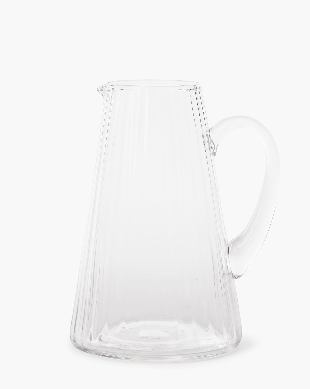 The Adonis Ribbed Glass Pitcher, featuring a wide base, narrow top, and curved handle, brings elegant style to any kitchen decor and is shown here against a plain white background by McGee & Co.