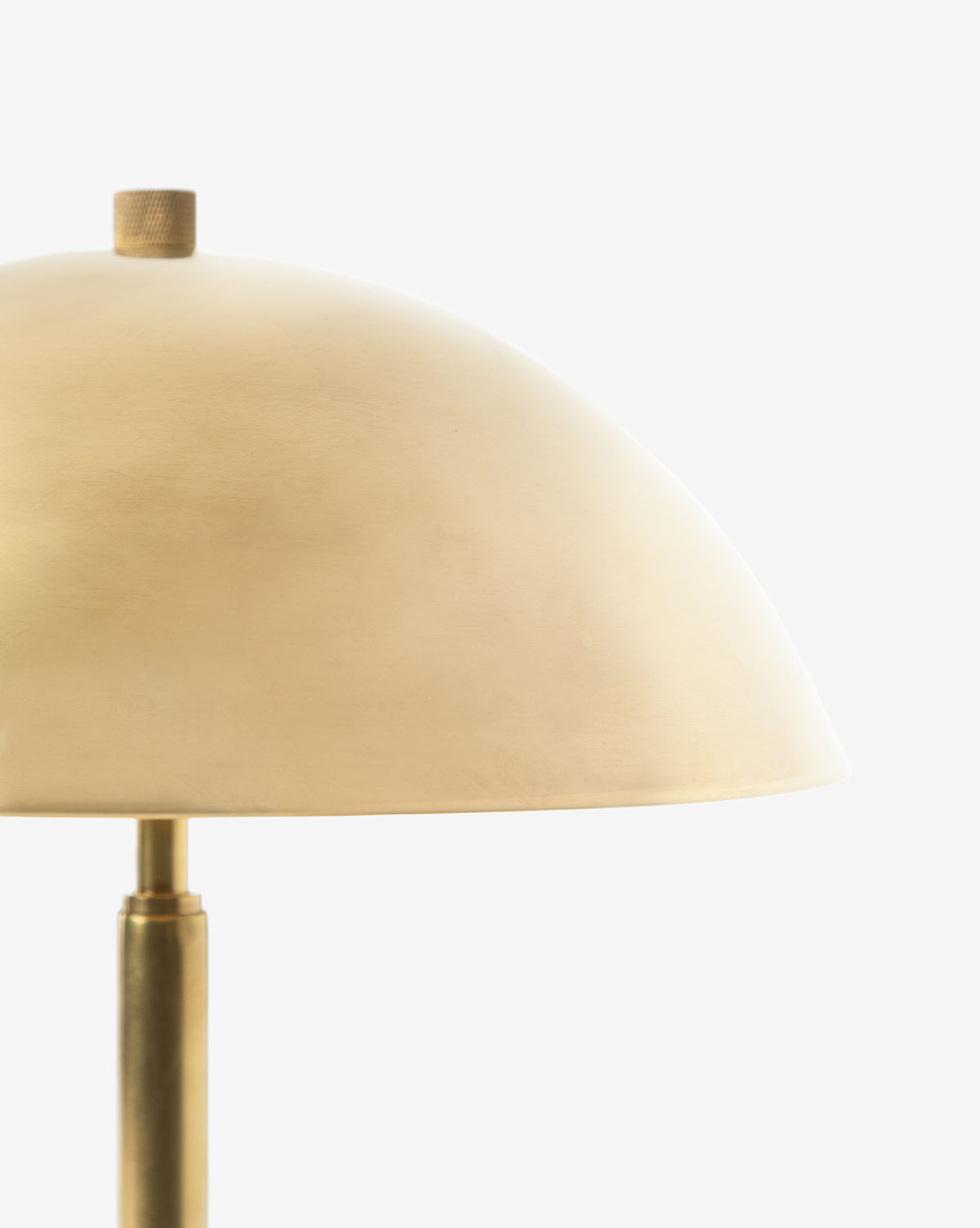 Close-up of the Aldorno Desk Table Lamp, featuring a modern brass finish and dome-shaped shade, perfect for living room lighting, shown against a plain white background by McGee & Co.