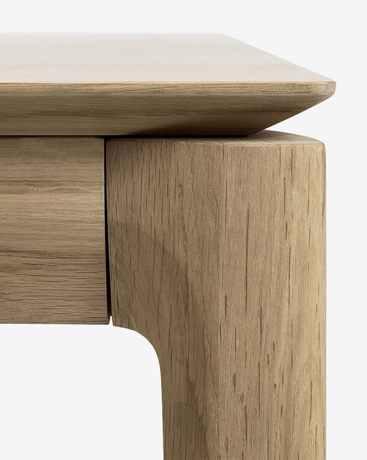 Close-up of the Alec Dining Table’s corner highlights its smooth, rounded edges and rich wood grain, showcasing durable craftsmanship—an ideal centerpiece for any dining room, set against a plain white background by McGee & Co.