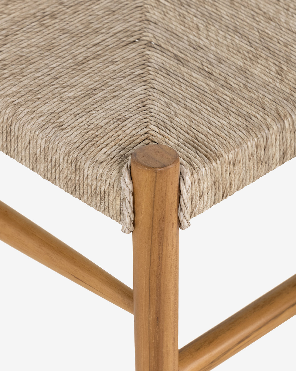 Close-up of the Ambler Indoor/Outdoor Dining Chair, showcasing its woven beige wicker seat and light wooden frame with smooth, rounded edges—ideal for both indoor and outdoor dining spaces, by McGee & Co.
