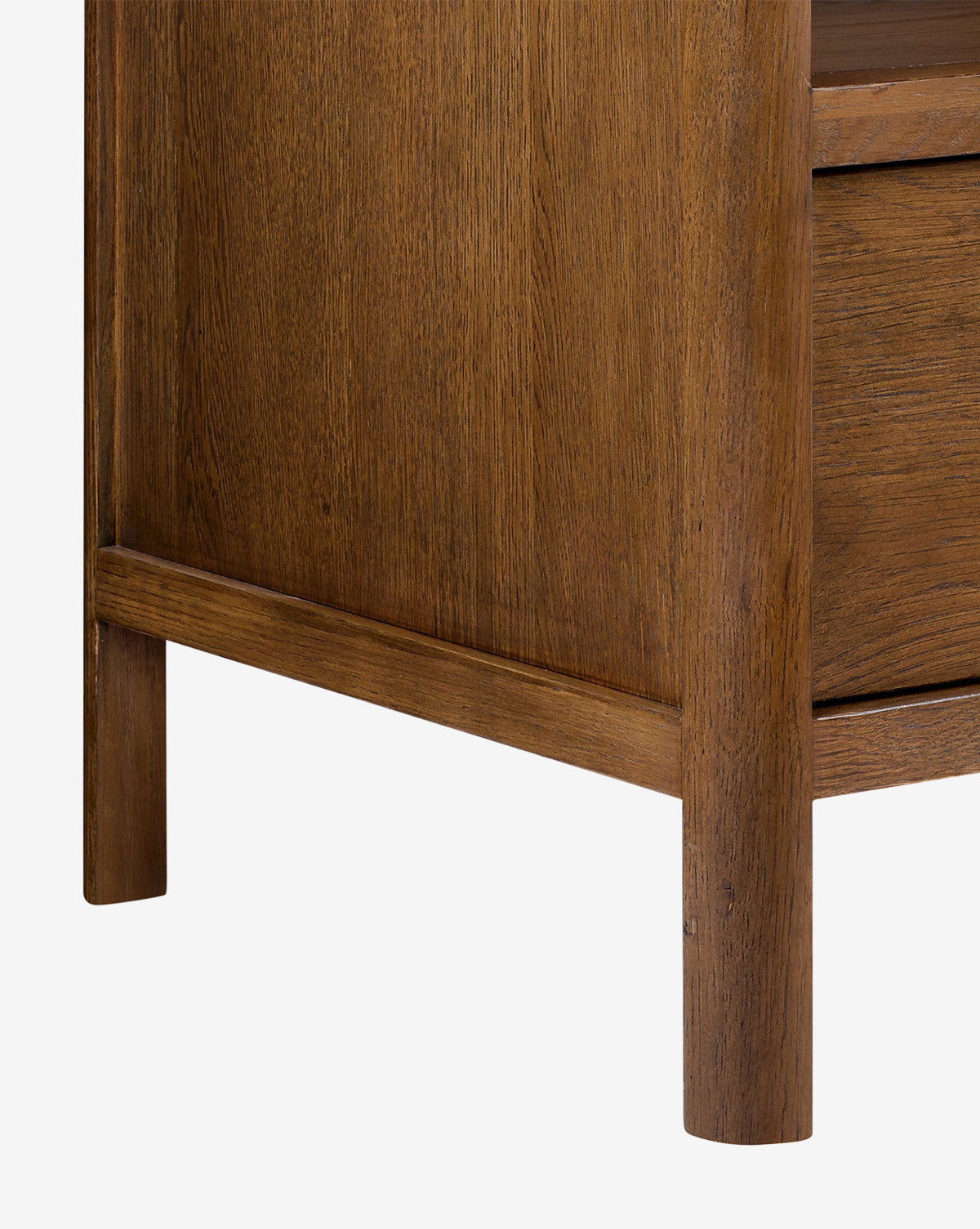 Close-up of the Ambrosia Nightstand’s corner reveals its walnut oak veneer, visible wood grain, one leg, part of the lower shelf, and elegant antique brass hardware, by McGee & Co.