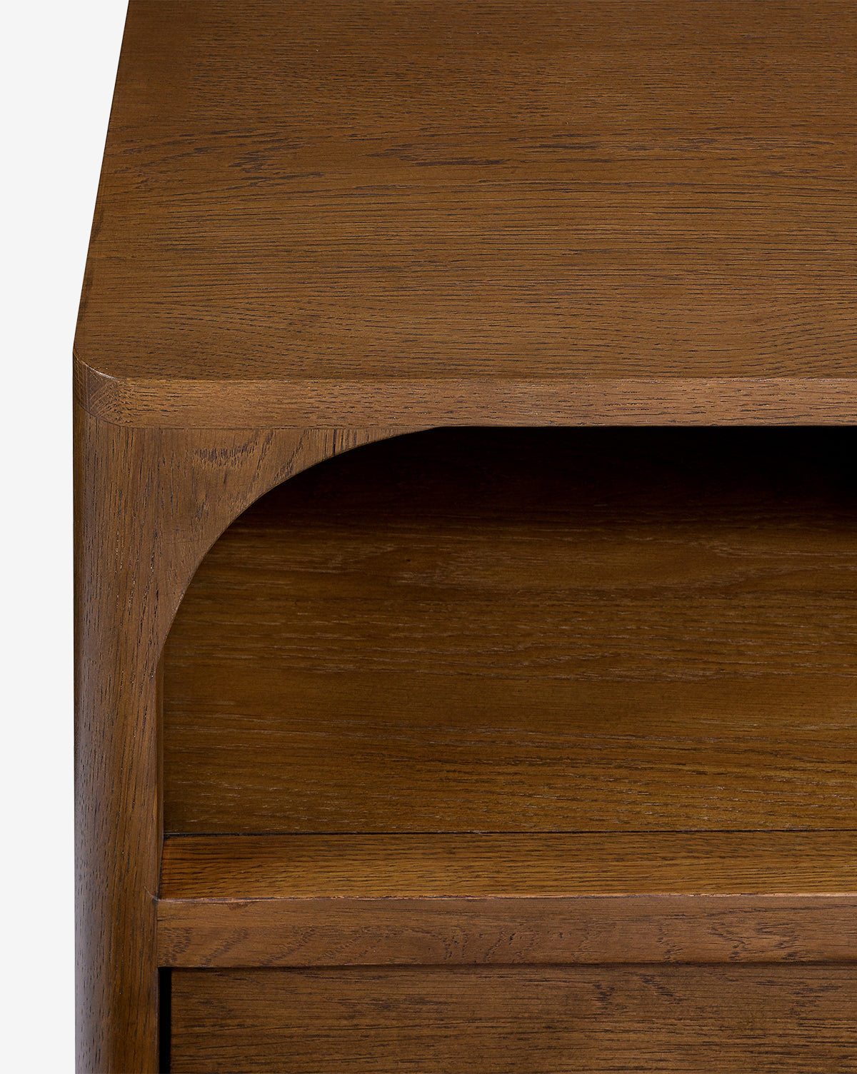 A close-up of the Ambrosia Nightstand shows its smooth surface, rounded corners, and open shelf. The warm medium-brown finish highlights the walnut oak veneer, giving this nightstand an elegant touch by McGee & Co.