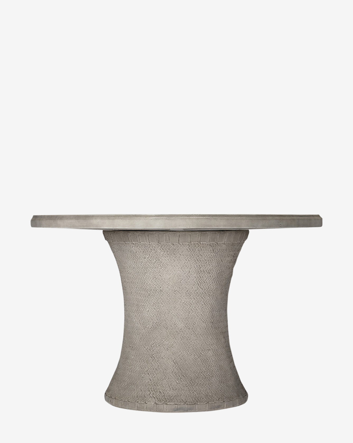 The Andrea Dining Table features a round, modern design with a thick basket weave pedestal base and a smooth, flat top in a gray concrete-like finish, shown against a white background by McGee & Co.