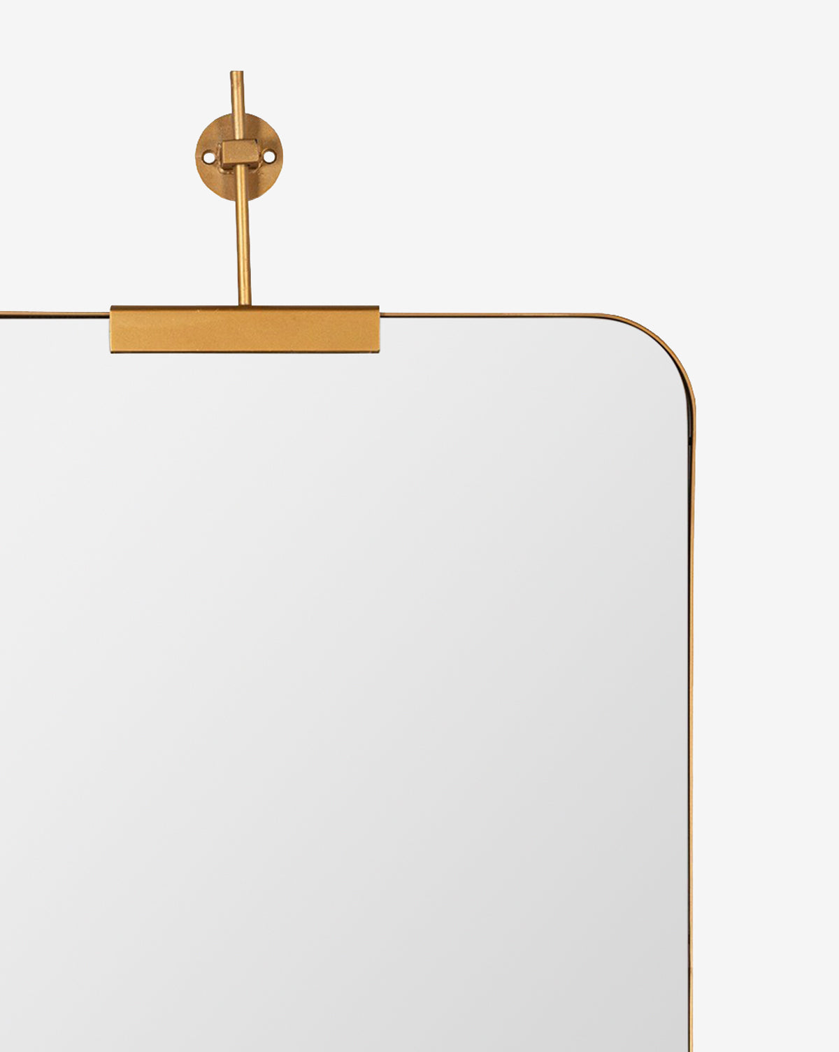 A close-up of the top right corner of the Anwen Wall Mirror, showing its rounded edges, gold metal frame, and gold mounting bracket against a plain white background, by McGee & Co.