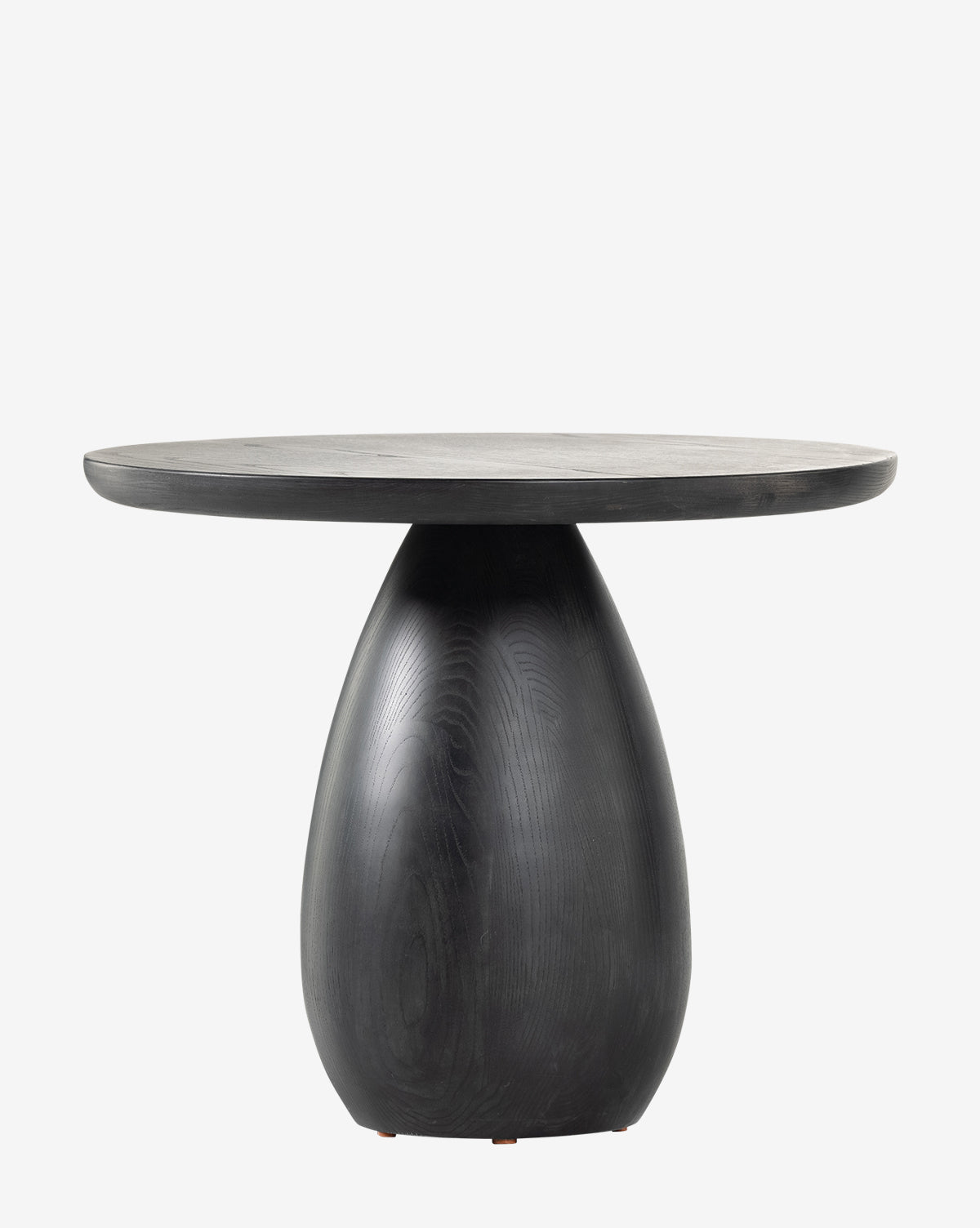 The Argus End Table is round and modern, with a smooth black-washed ash top and a thick, rounded, tapering solid ash base, shown against a plain white background by McGee & Co.