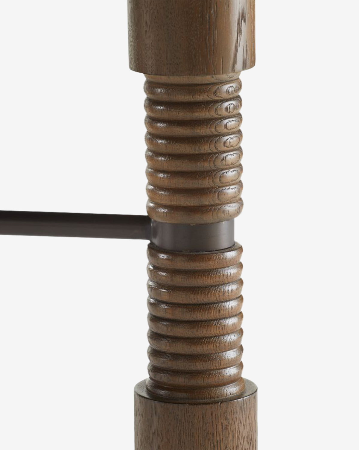 Close-up of the Ashford Dining Table’s wooden leg with horizontal ribbed grooves and a dark metal support rod, highlighting its polished brown finish and vintage-inspired design, by McGee & Co.
