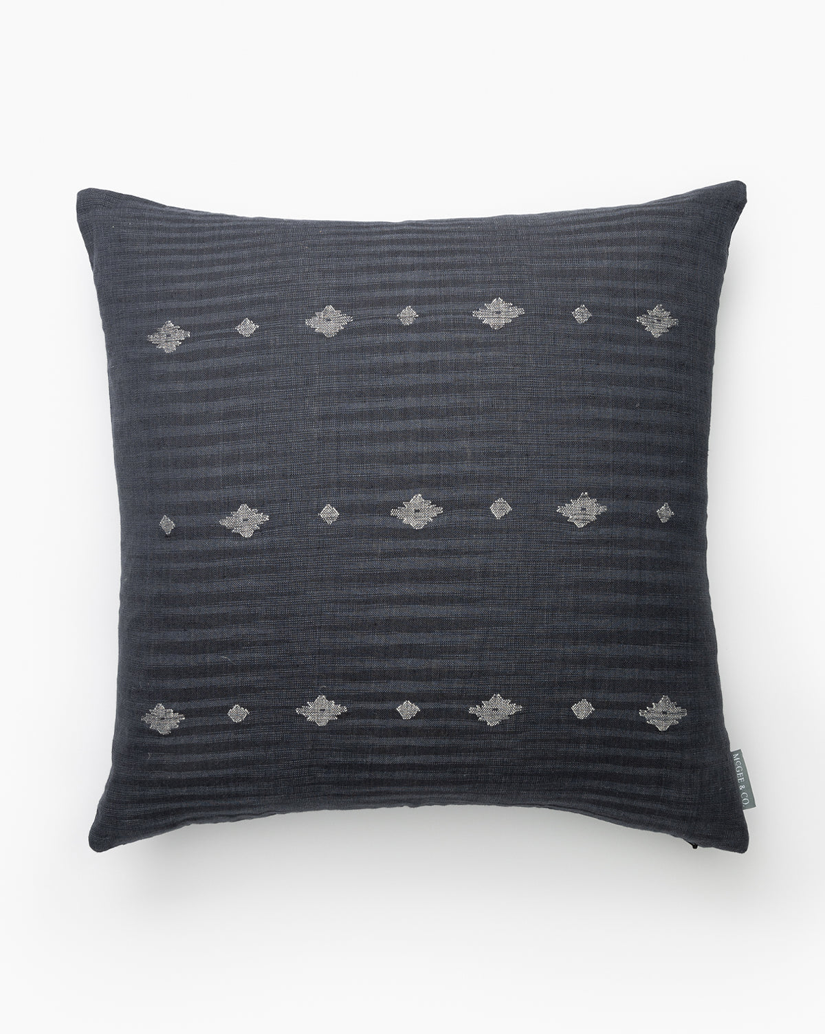 The Atilla Pillow Cover, crafted from navy linen cotton, showcases subtle horizontal stripes and small, evenly spaced silver geometric embroidery, set against a white background, by McGee & Co.