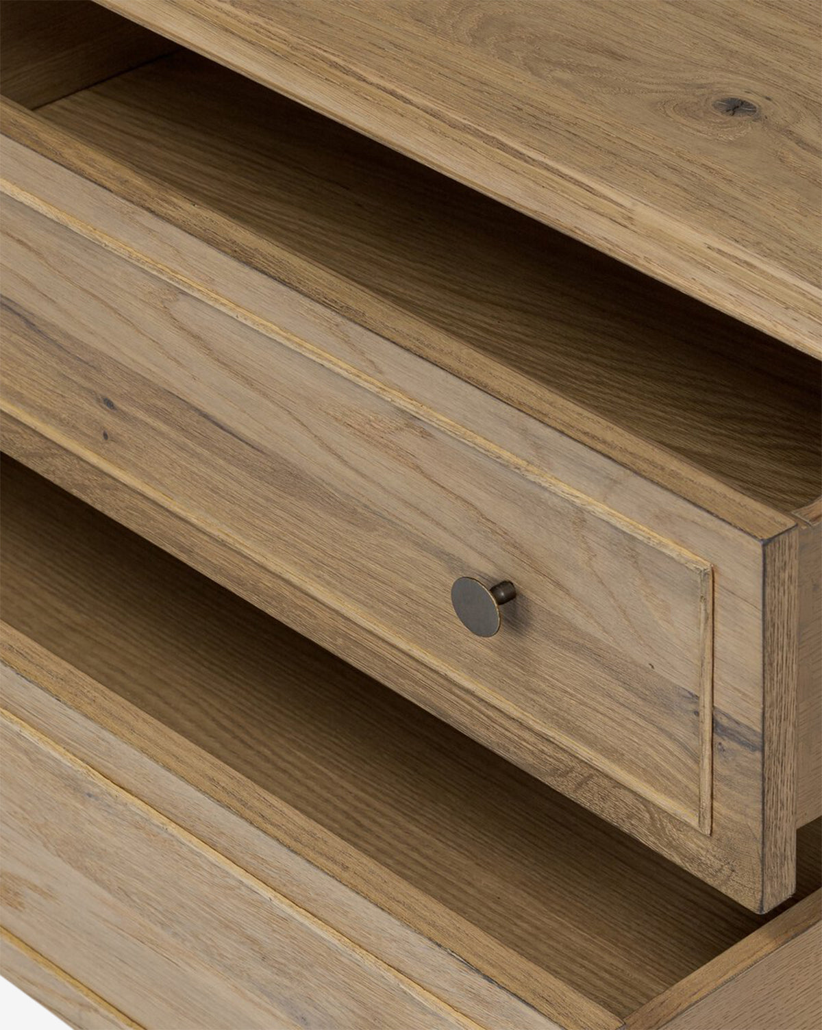 Close-up view of the Aurelian Nightstand, crafted in smoked oak with a single drawer featuring a round black knob, an open shelf above, and a lower open compartment—ideal for stylish bedroom storage, by McGee & Co.