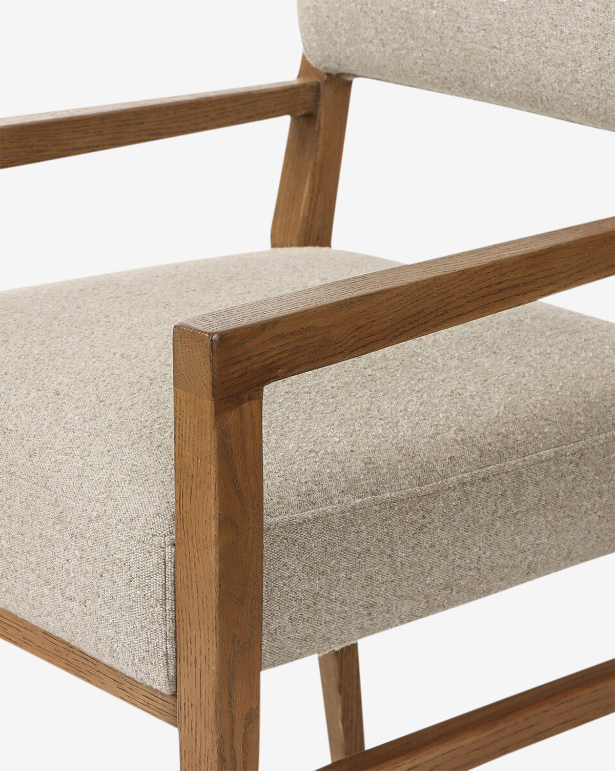 A close-up of the Bailey Dining Arm Chair, featuring a smoked oak frame and light beige upholstery, highlights its modern minimalist design with clean lines, by McGee & Co.