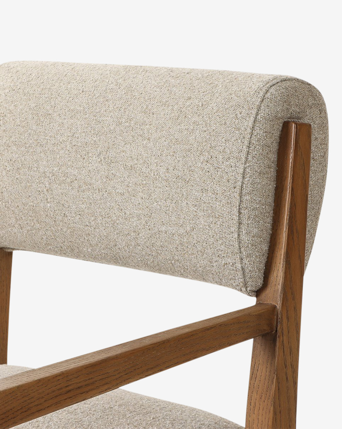 Close-up of the Bailey Dining Arm Chair, featuring a light beige upholstered backrest and seat with a smoked oak frame, angled armrests, and support structure against a white background, by McGee & Co.
