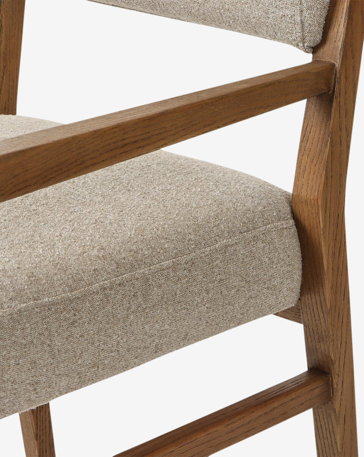 A close-up of the Bailey Dining Arm Chair shows its light beige upholstered seat and backrest, complemented by a light brown smoked oak frame in a simple, modern design with clean lines by McGee & Co.