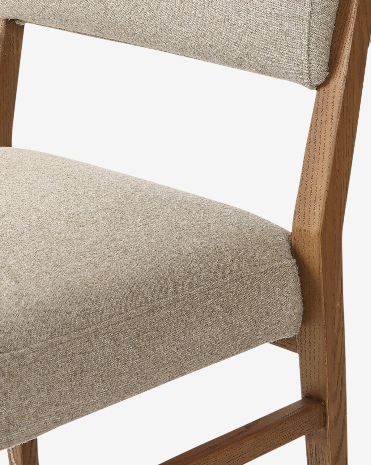 A close-up of the Bailey Dining Chair reveals its light beige upholstery and natural smoked oak wood grain, emphasizing the fabric texture and elegant design, by McGee & Co.