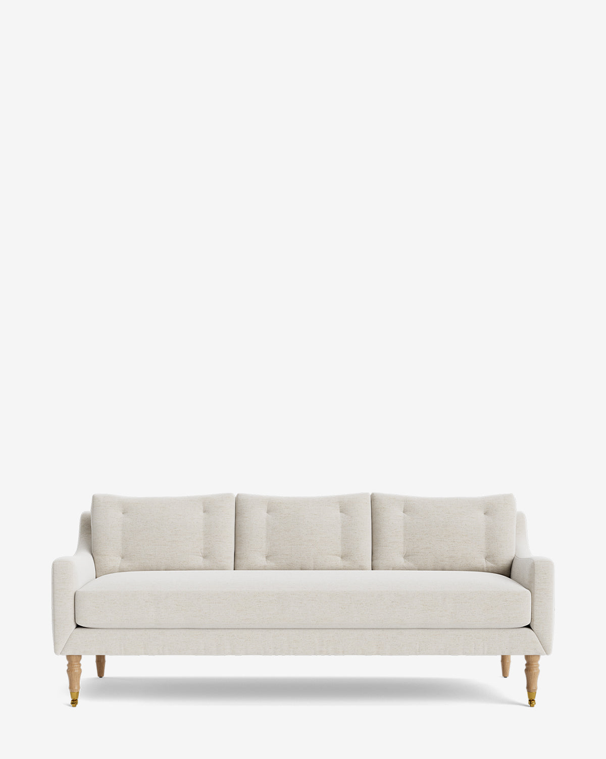 The Barden Sofa 84 showcases light beige upholstery, three seat and back cushions with subtle tufting, reeded wood legs, and is photographed against a plain white background, by McGee & Co.