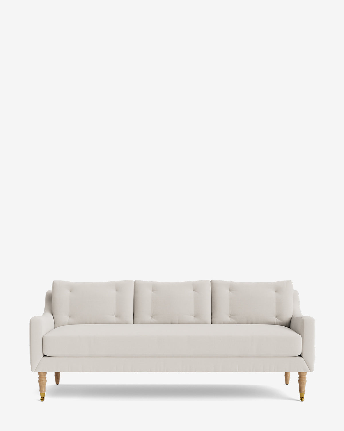 The Barden Sofa 84 is a modern cream sofa with three seat and back cushions, slim arms, tufted detailing, and reeded wood legs, shown against a plain white background by McGee & Co.