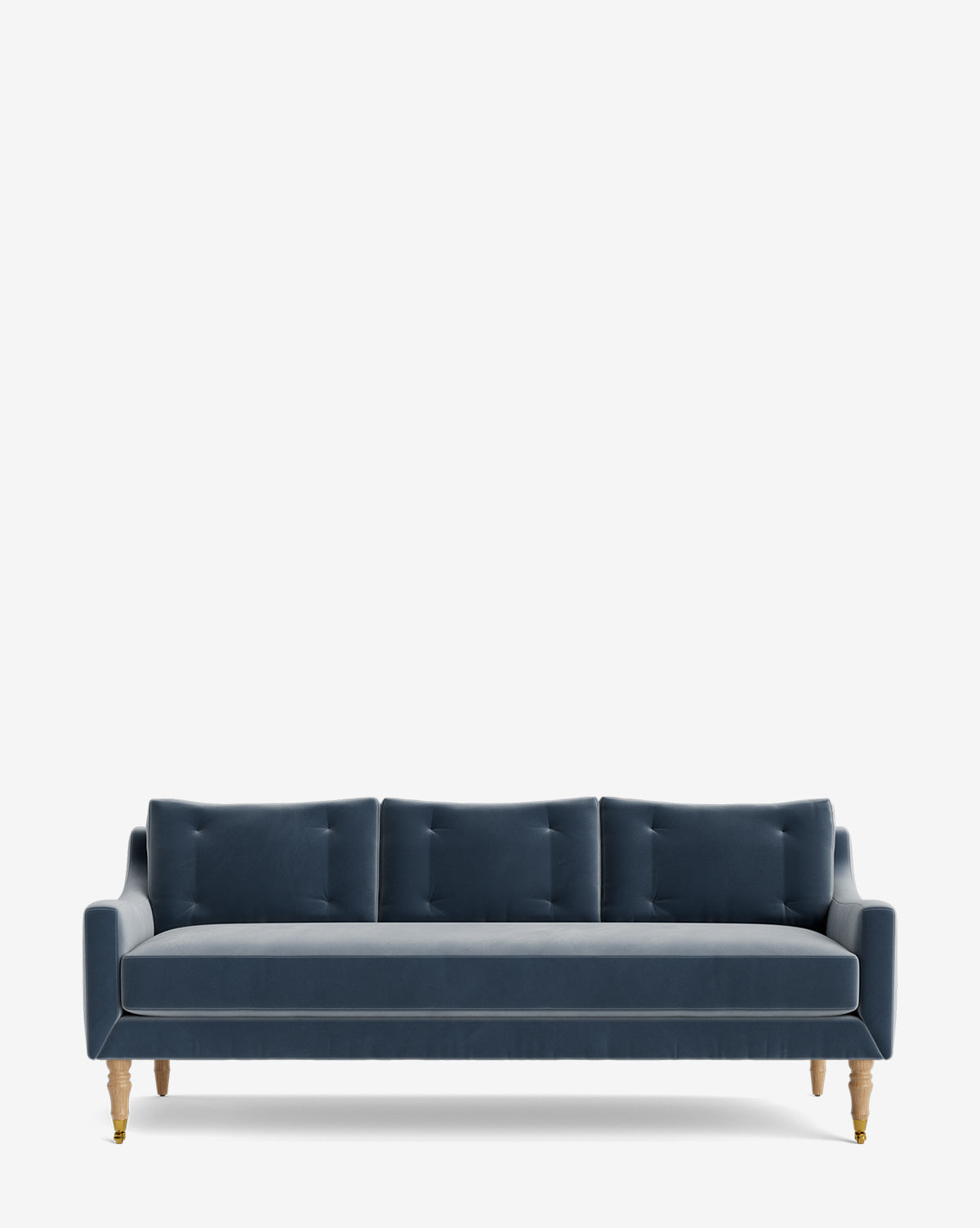 The Barden Sofa 84 has a dark blue velvet finish, three seat cushions, tufted back cushions, and reeded wood legs. Set on a plain white background, it exudes timeless style by McGee & Co.