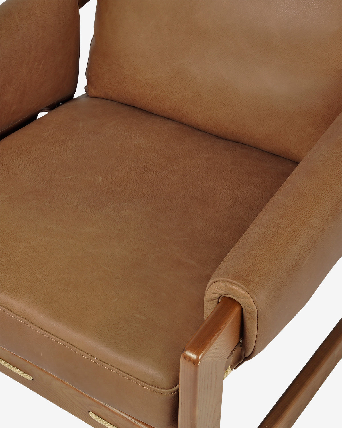 Close-up of the Barker Lounge Chair in top-grain leather with wooden armrests and frame, focusing on the seat, cushion, and backrest against a white background by McGee & Co.