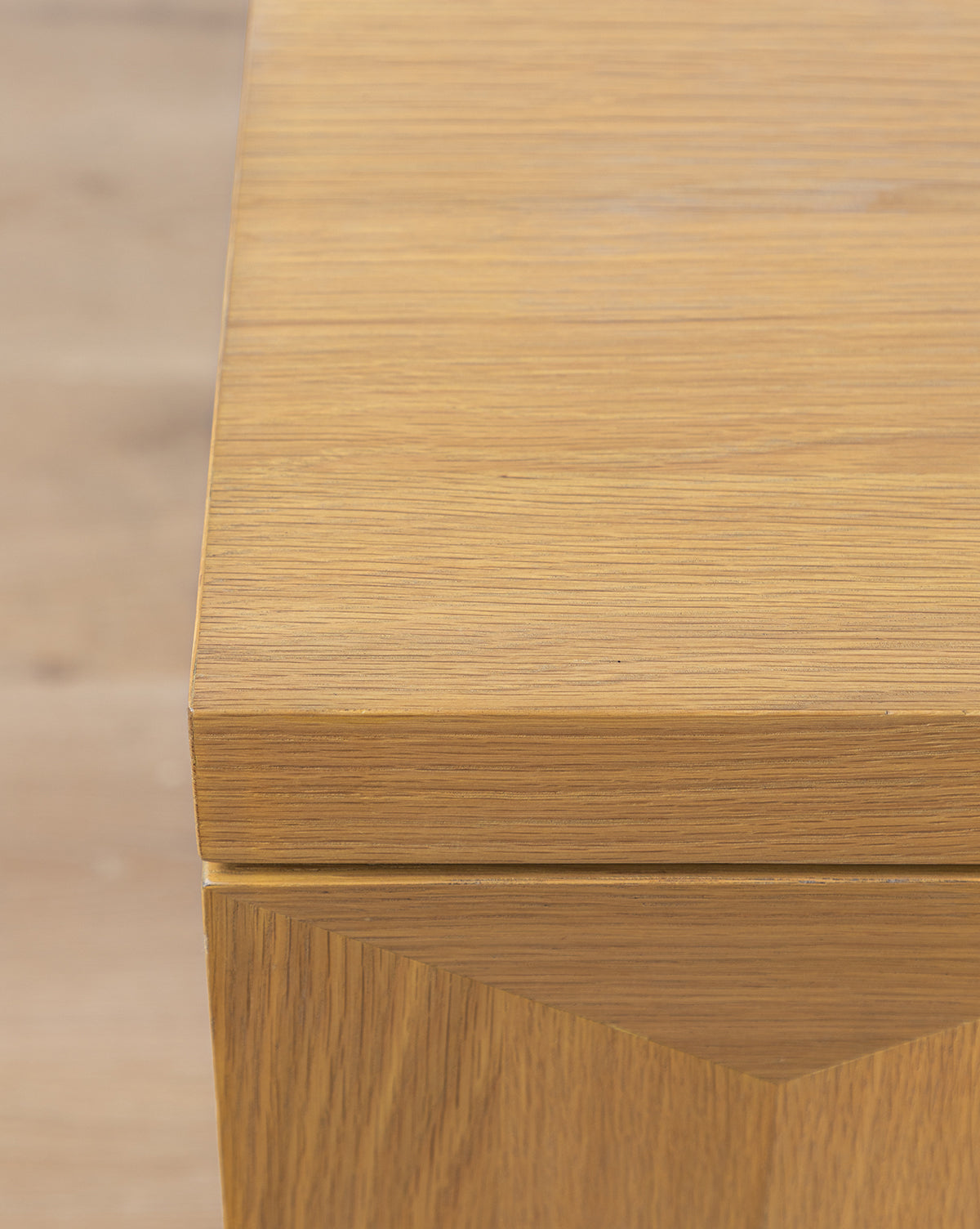 Close-up of the Beacon Nightstand’s corner, featuring smooth light wood and visible grain, ideal as a modern nightstand or bedroom storage, set against a blurred light wood background, by McGee & Co.
