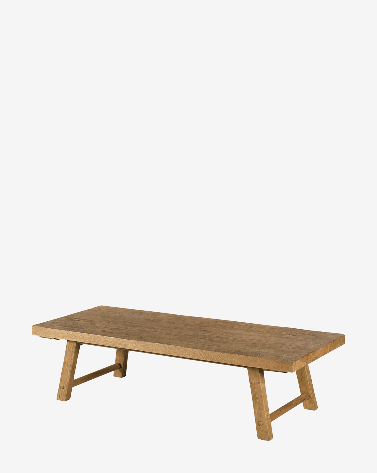 The Belfield Coffee Table is a low, rectangular rustic piece with a simple organic design and four angled wooden legs, shown against a plain white background by McGee & Co.