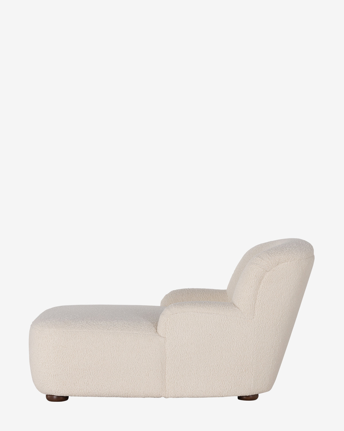 Side view of the Berrett Chaise Lounge, a modern armless chair in off-white shearling with a low seat, rounded edges, and short dark feet—ideal for enhancing any living space, by McGee & Co. Shown against a plain white background.