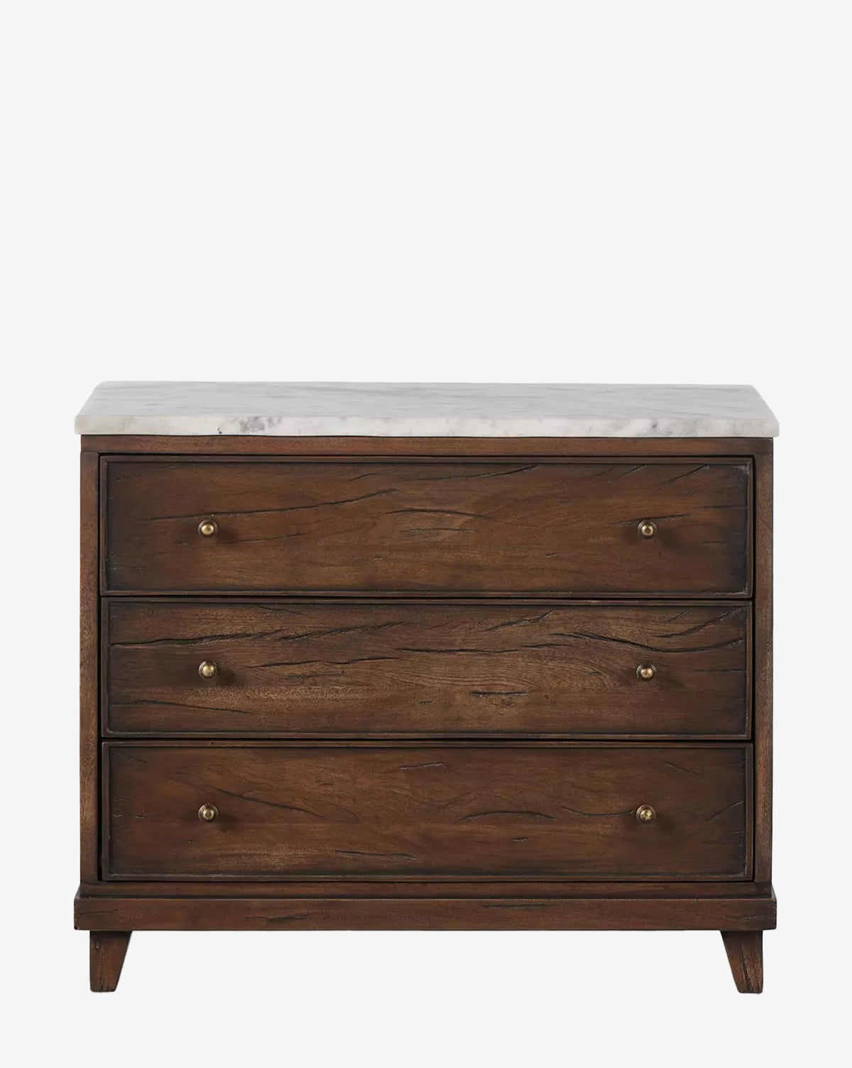 The Bettiga Nightstand features three drawers, brass hardware, tapered legs, and a white marble top. Made from antique reclaimed wood with a dark finish and visible grain patterns. Shown against a plain white background by McGee & Co.