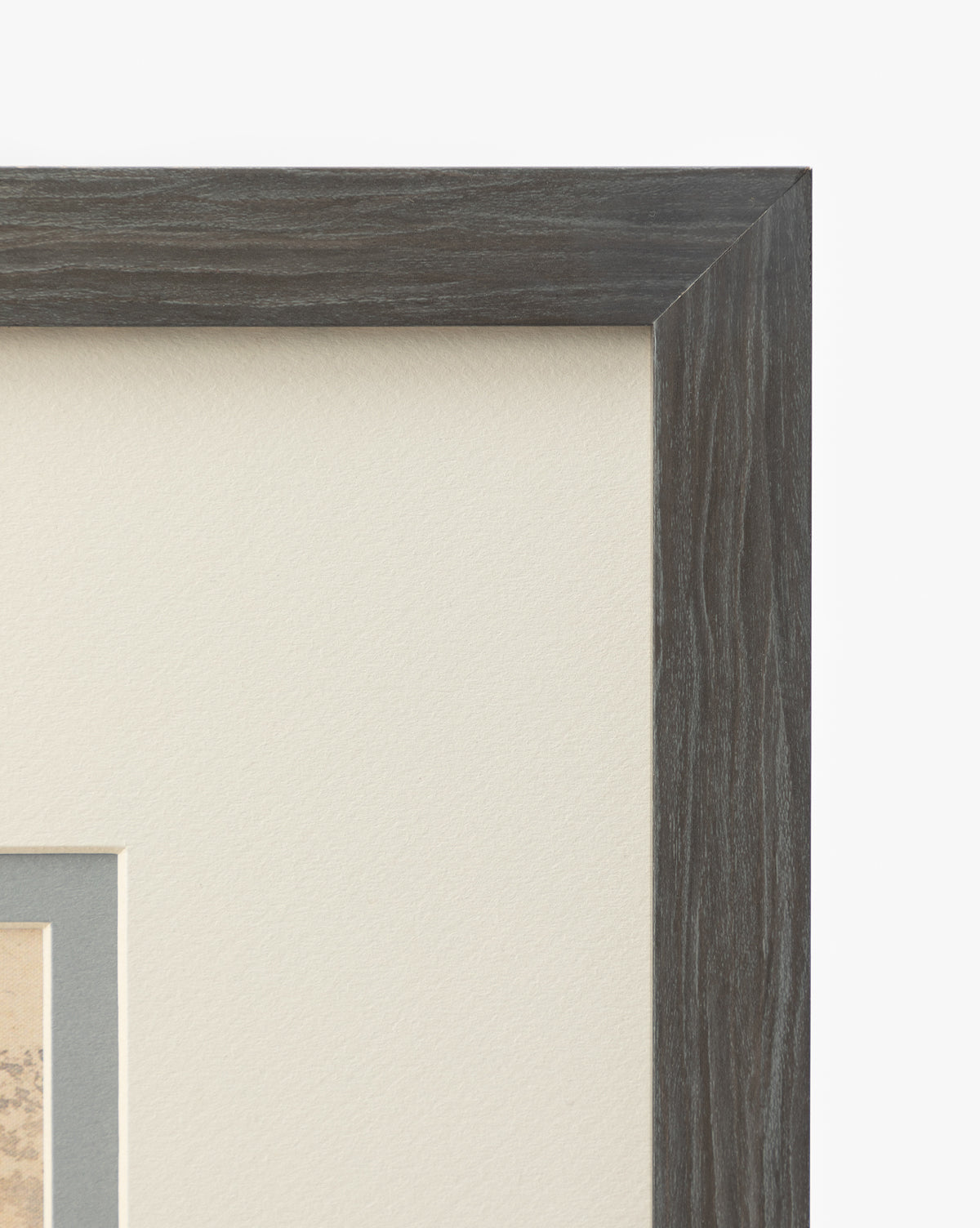 Close-up of the top right corner of a charcoal woodgrain frame holding the matted Blue Fruits botanical art piece on off-white mat board, set against a white background, by McGee & Co.