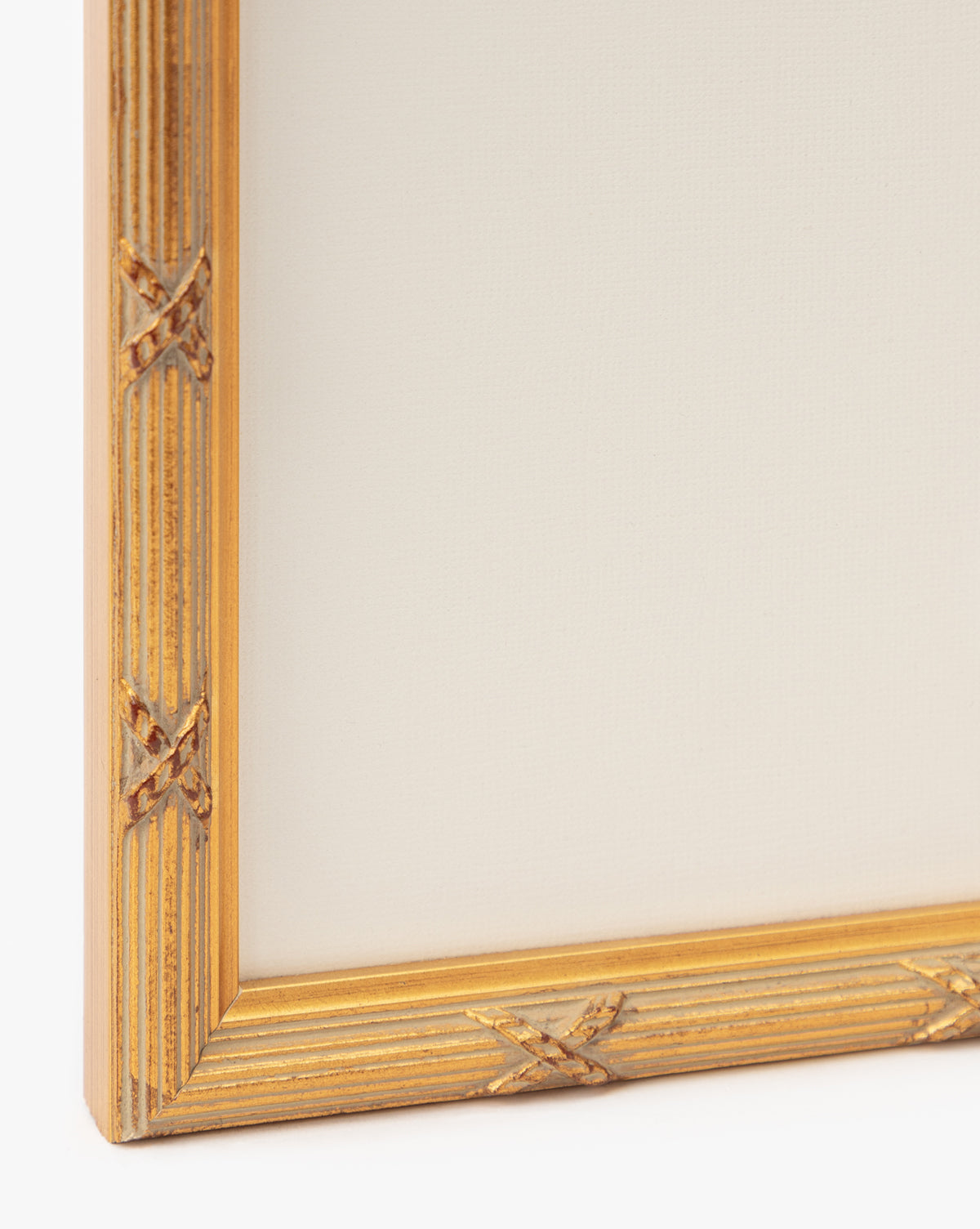 A close-up of a gold frame with carved details, surrounding a blank canvas ready to showcase Botanical Grid 1—ideal for displaying elegant botanical wall art by McGee & Co.