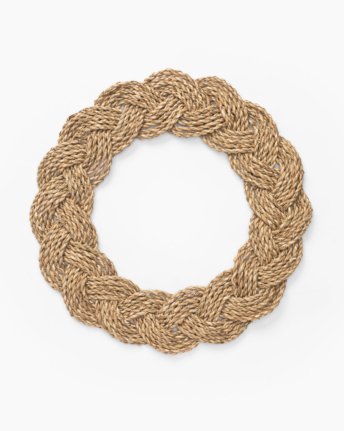 A Braided Placemat crafted from thick, brown rope and arranged in a coastal-inspired, circular woven pattern is displayed on a plain white background by McGee & Co.