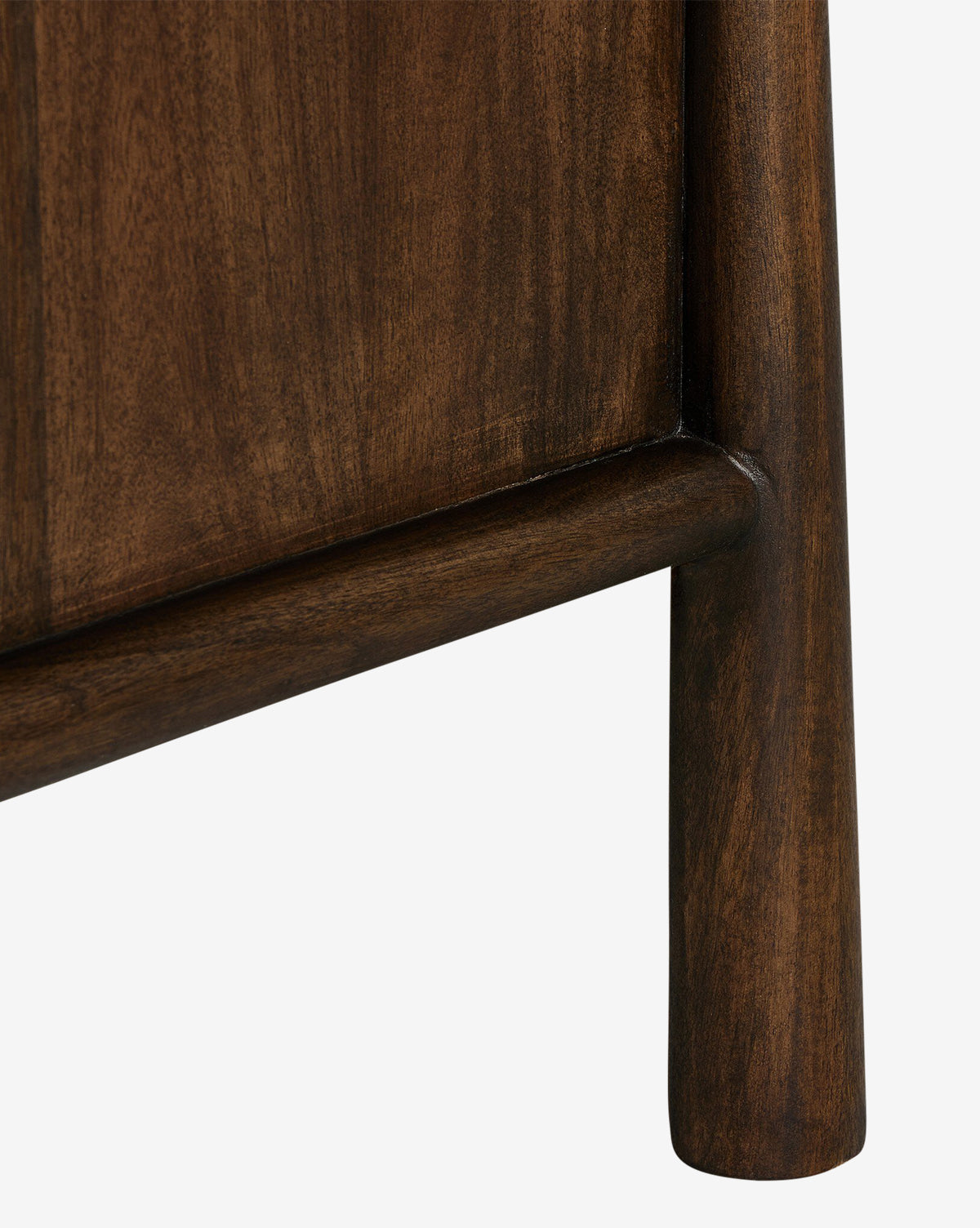 Close-up of the Bridgewater Nightstands wooden leg and lower frame, finished in dark brown with smooth, rounded edges—part of a modern antique design that includes practical storage drawers, by McGee & Co. Set against a white background.