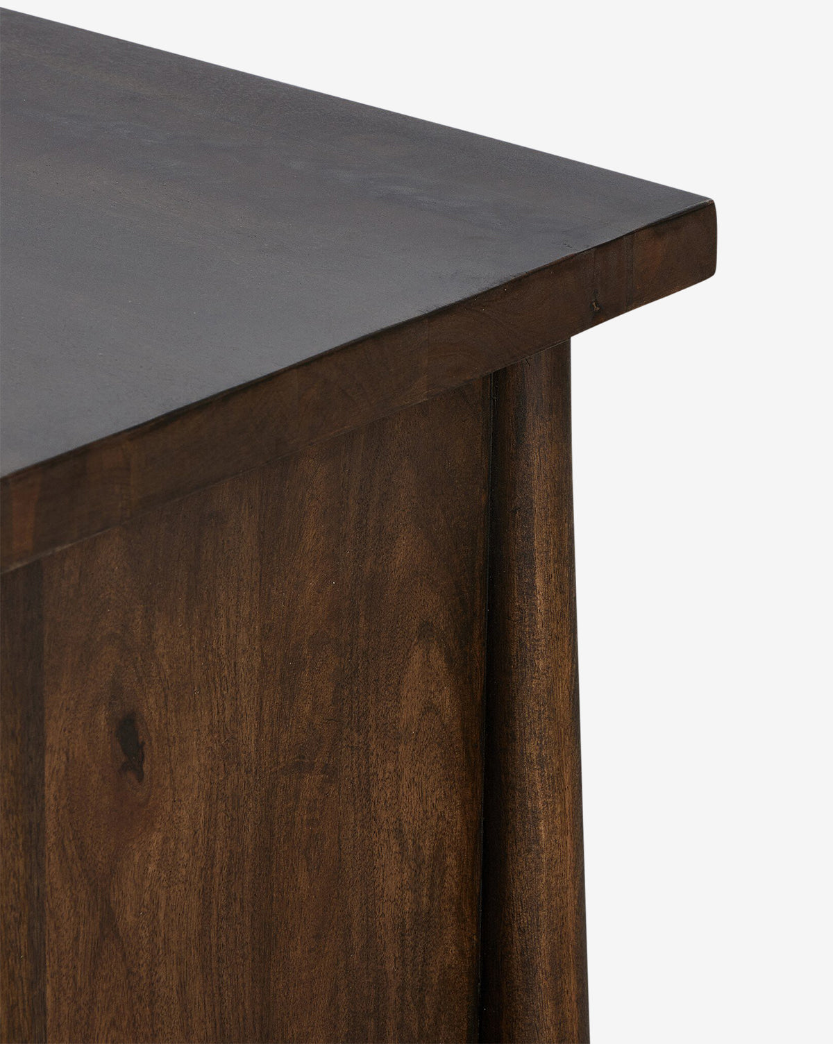 Close-up of the Bridgewater Nightstand’s corner, showcasing its dark, smooth wood finish with visible grain and iron drawer pulls, set against a plain white background by McGee & Co.