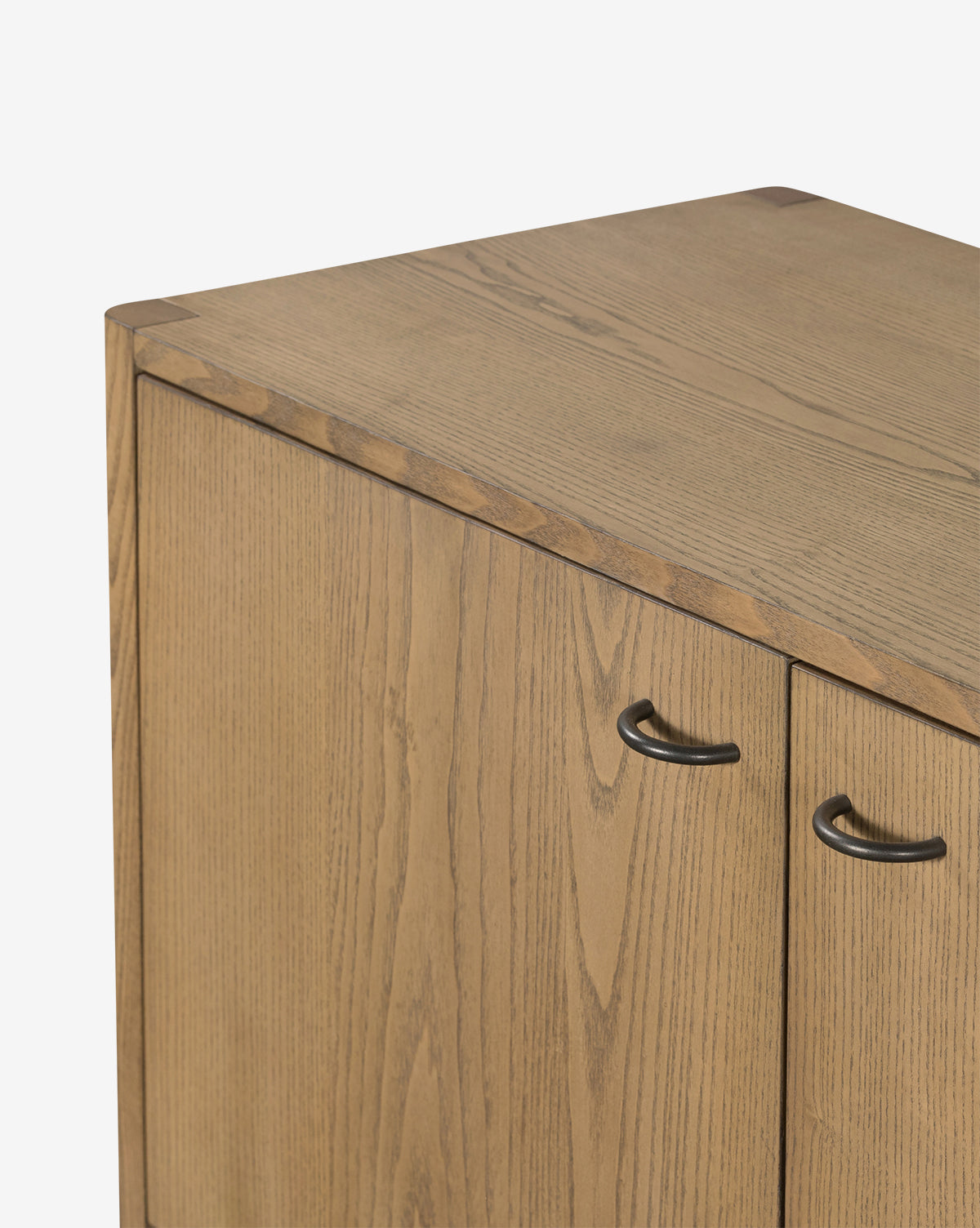 Close-up of the Brio Sideboard’s top corner, showcasing its two doors, light brown solid ash wood grain finish, and black curved handles inspired by Danish design, by McGee & Co.