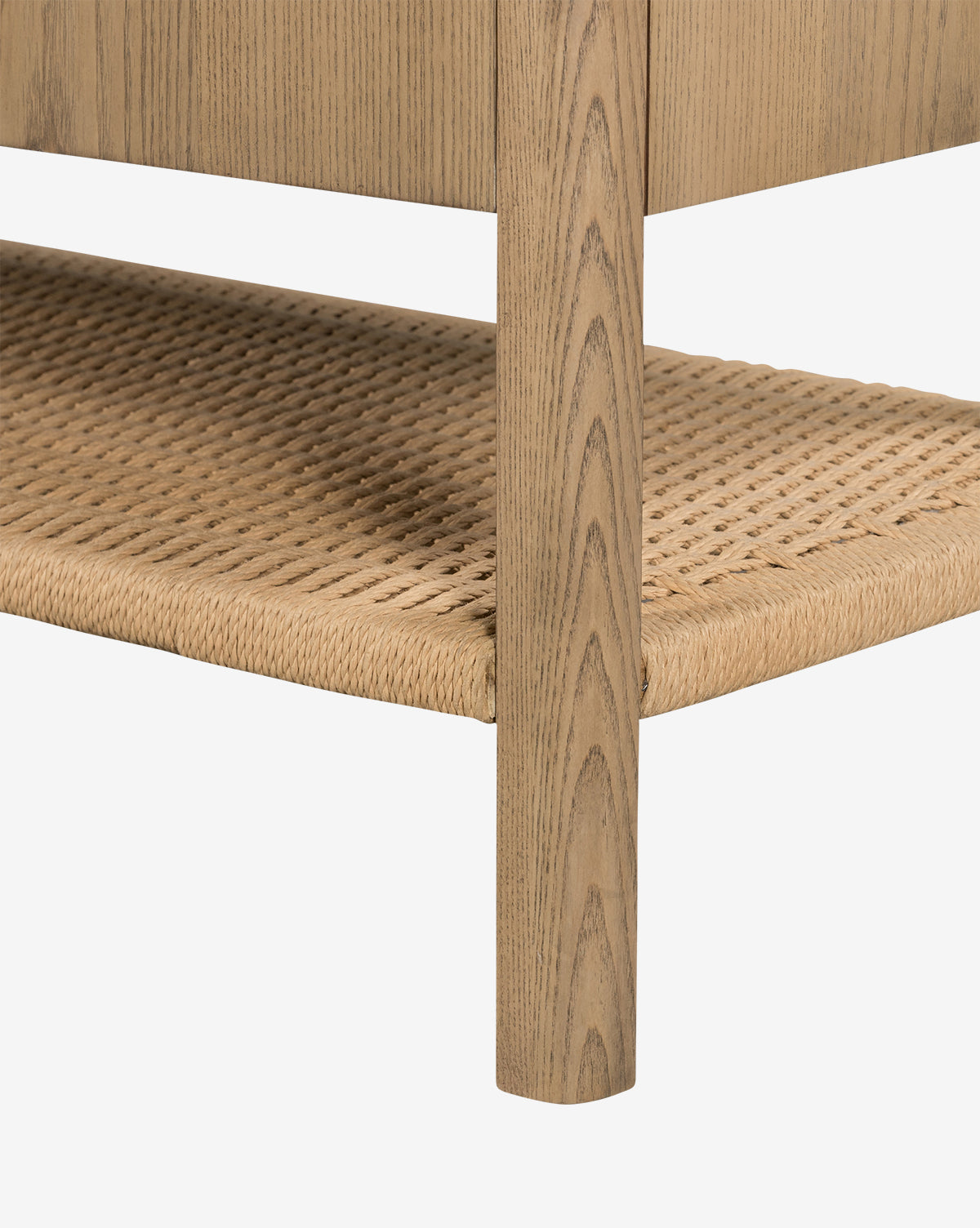 Close-up of the Brio Sideboard’s solid ash wood leg and woven rattan lower shelf, showcasing Danish design details and natural wood grain against a plain white background, by McGee & Co.