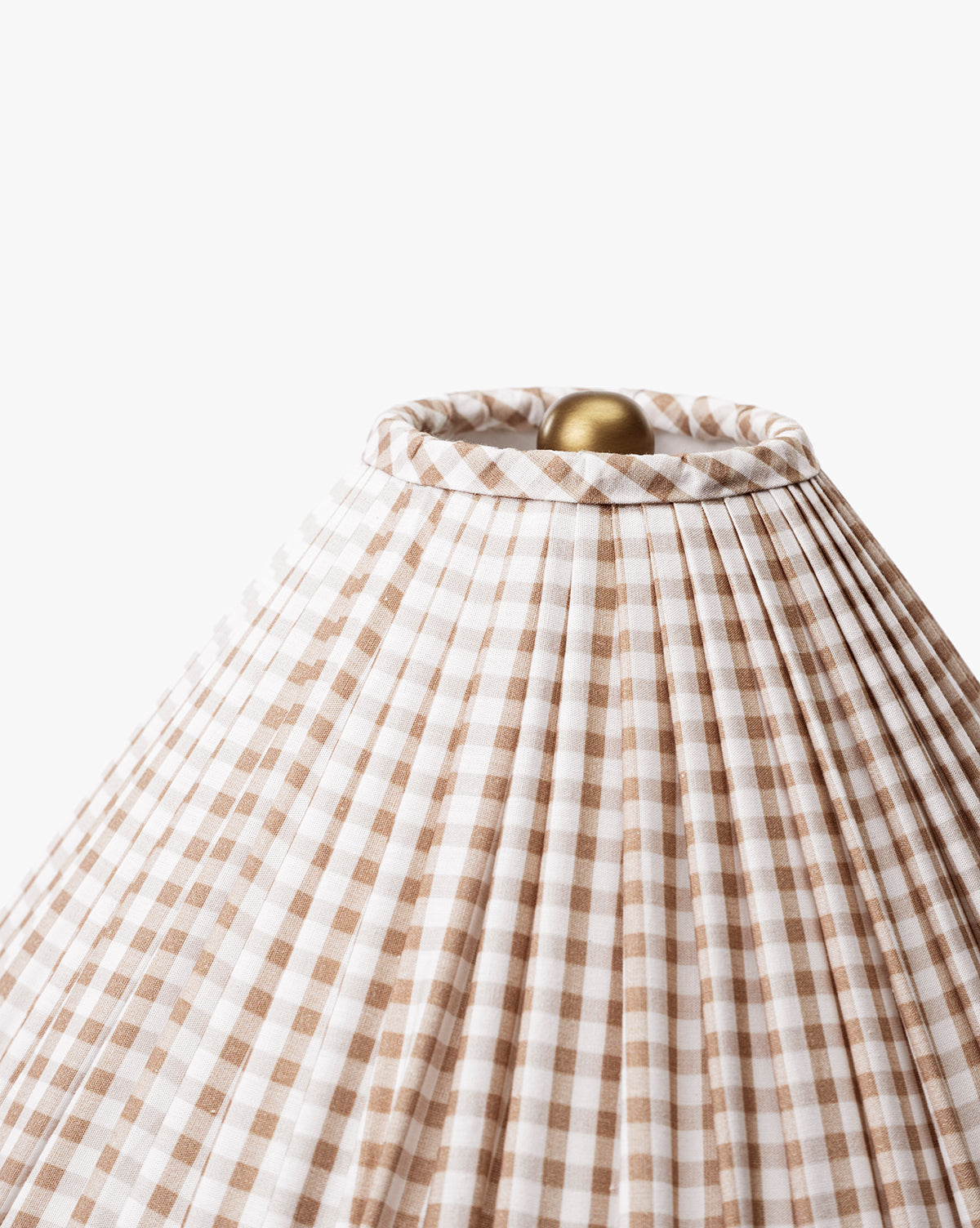 Close-up of the Bronwyn Table Lamps tan and white gingham pleated shade, featuring a round gold finial—ideal for vintage decor—shown against a plain white background, by McGee & Co.