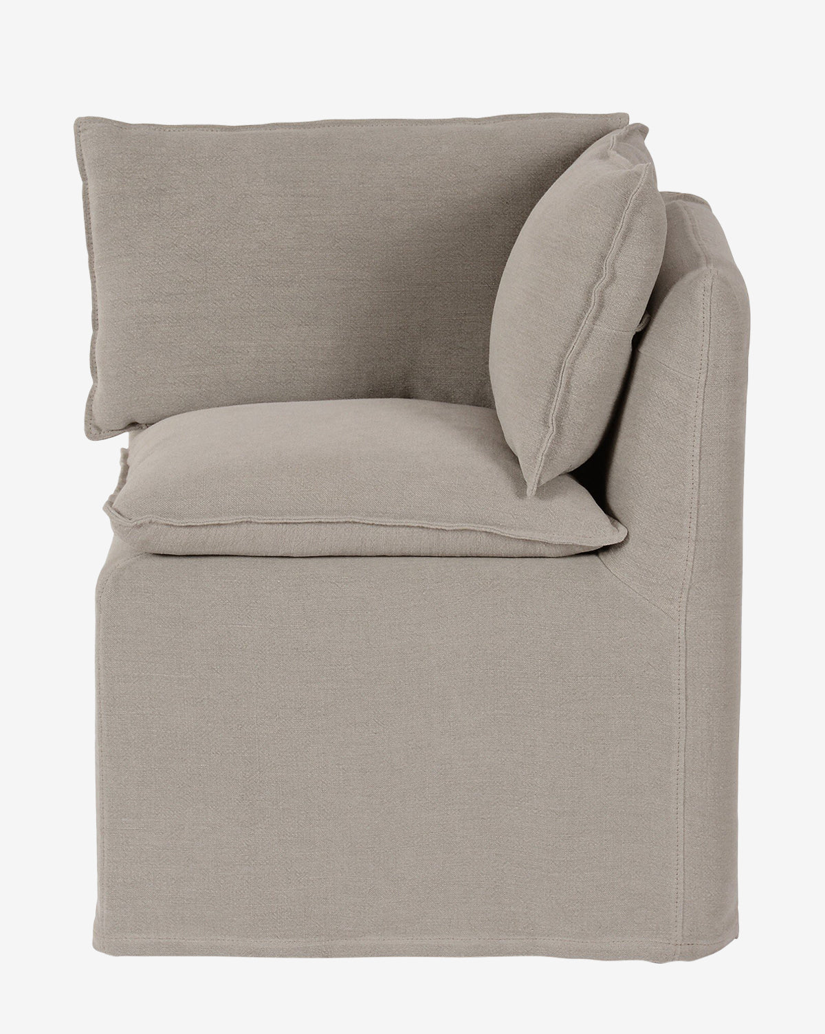 The Brookings Slipcover Corner is shown from the side, featuring beige linen-blend upholstery, plush cushions, and two back pillows that highlight its clean lines and soft texture against a white background by McGee & Co.