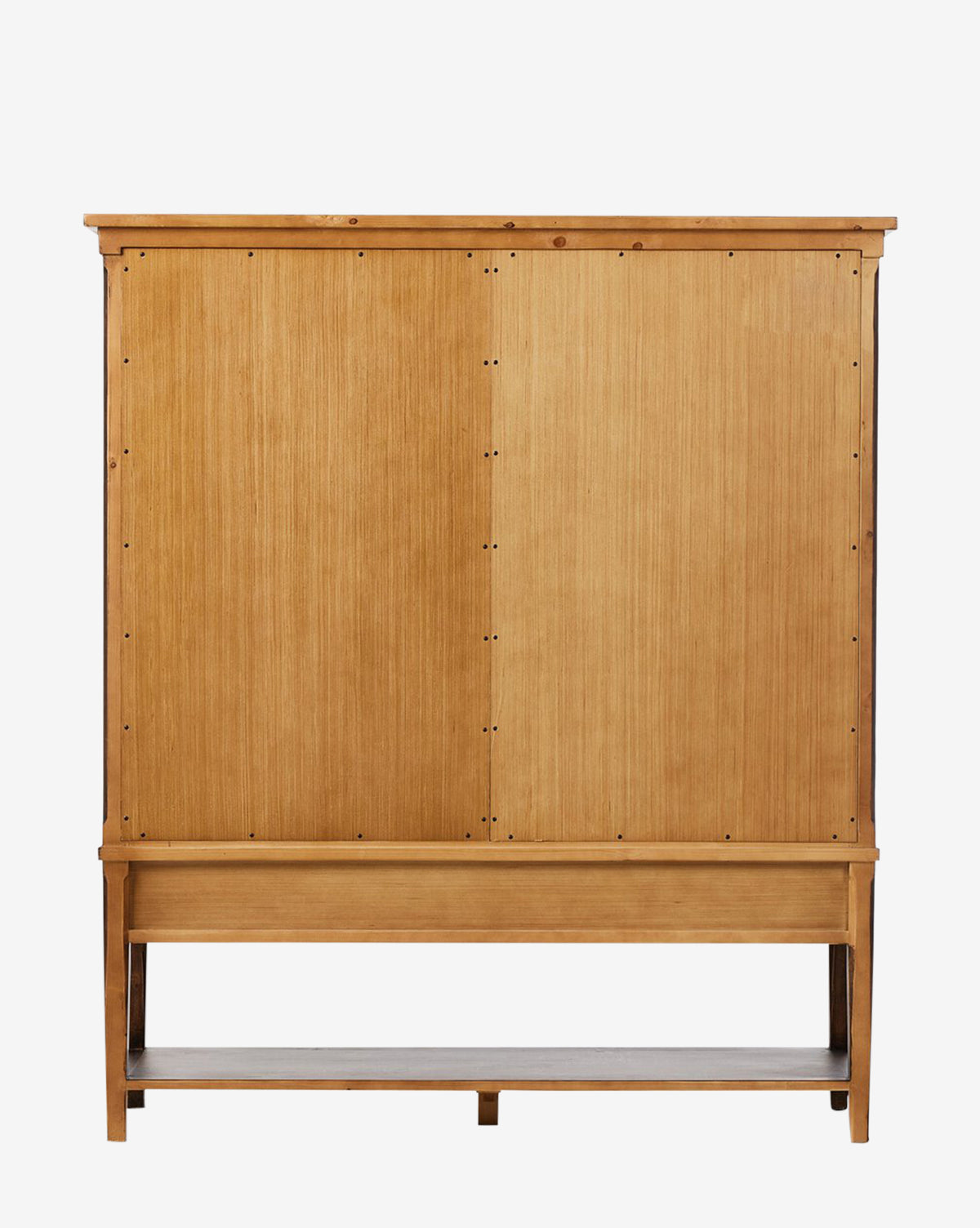 The Bryn Cabinet is crafted from solid pine with vertical paneling. It features two large sliding doors with distressed copper hardware and a lower open shelf, set against a plain white background by McGee & Co.