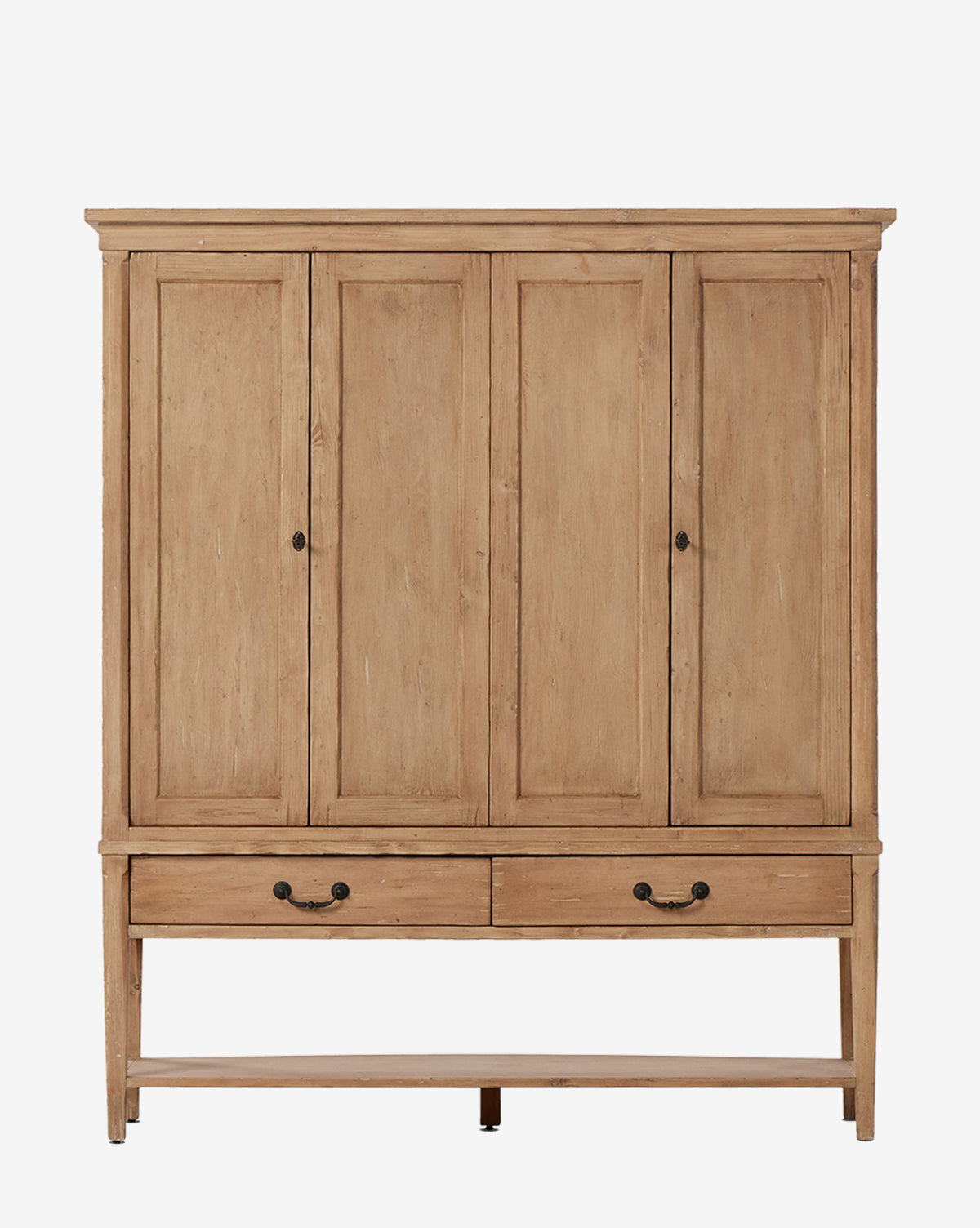 The Bryn Cabinet is a large solid pine cabinet with four paneled doors, two bottom drawers, distressed copper hardware, and a natural light brown finish by McGee & Co.