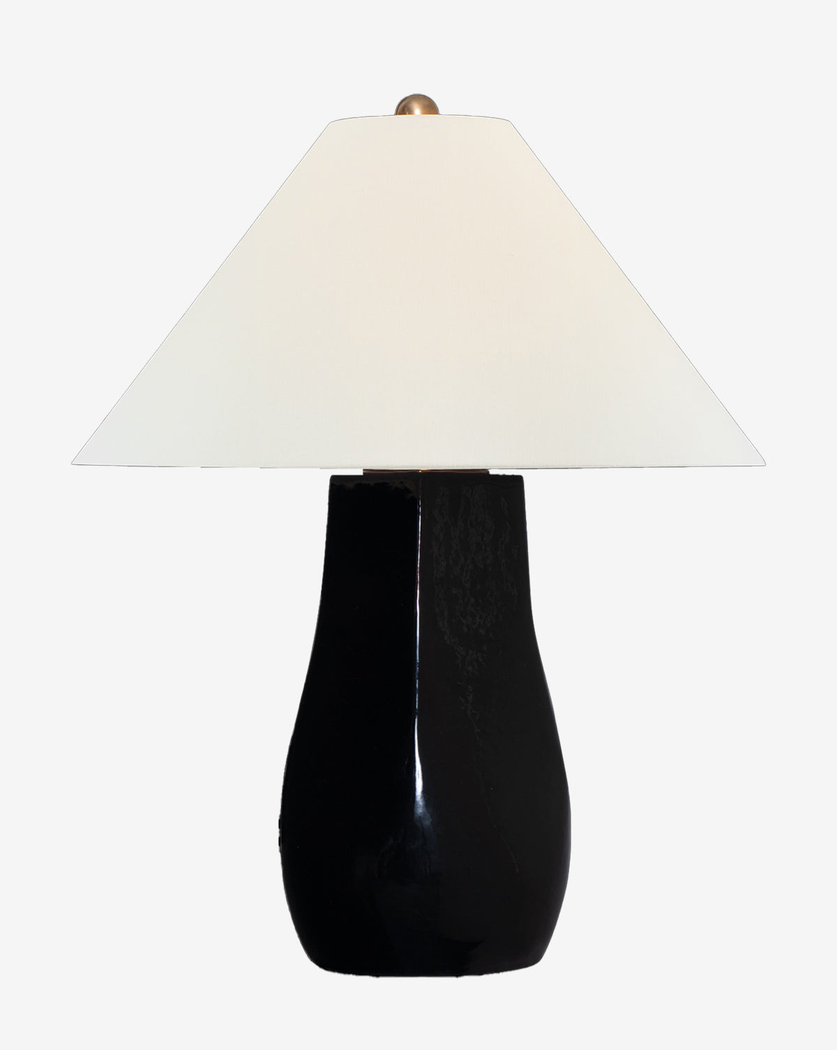 The Cabazon Table Lamp features a glossy black, curved base paired with a wide white linen shade, displayed against a plain white background by McGee & Co.