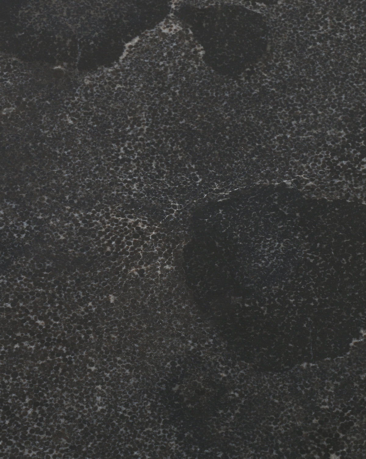 With its dark, textured surface featuring irregular speckles and bold black spots, the Caleb Side Table showcases a modern accent look and sturdy tripod base inspired by stone or concrete.