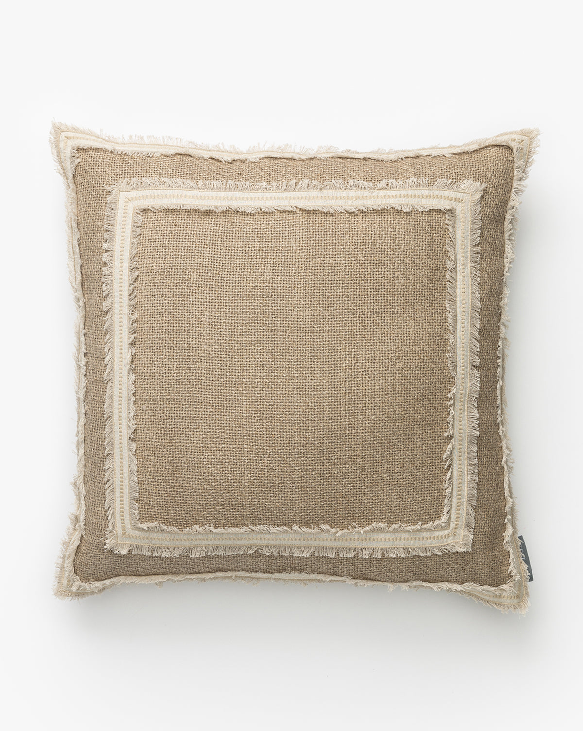 The Cameron Pillow Cover features a square shape with textured beige fabric, a lighter double-fringed and inner border, subtle rustic style, and a small fabric tag on one side for a neutral, layered look by McGee & Co.